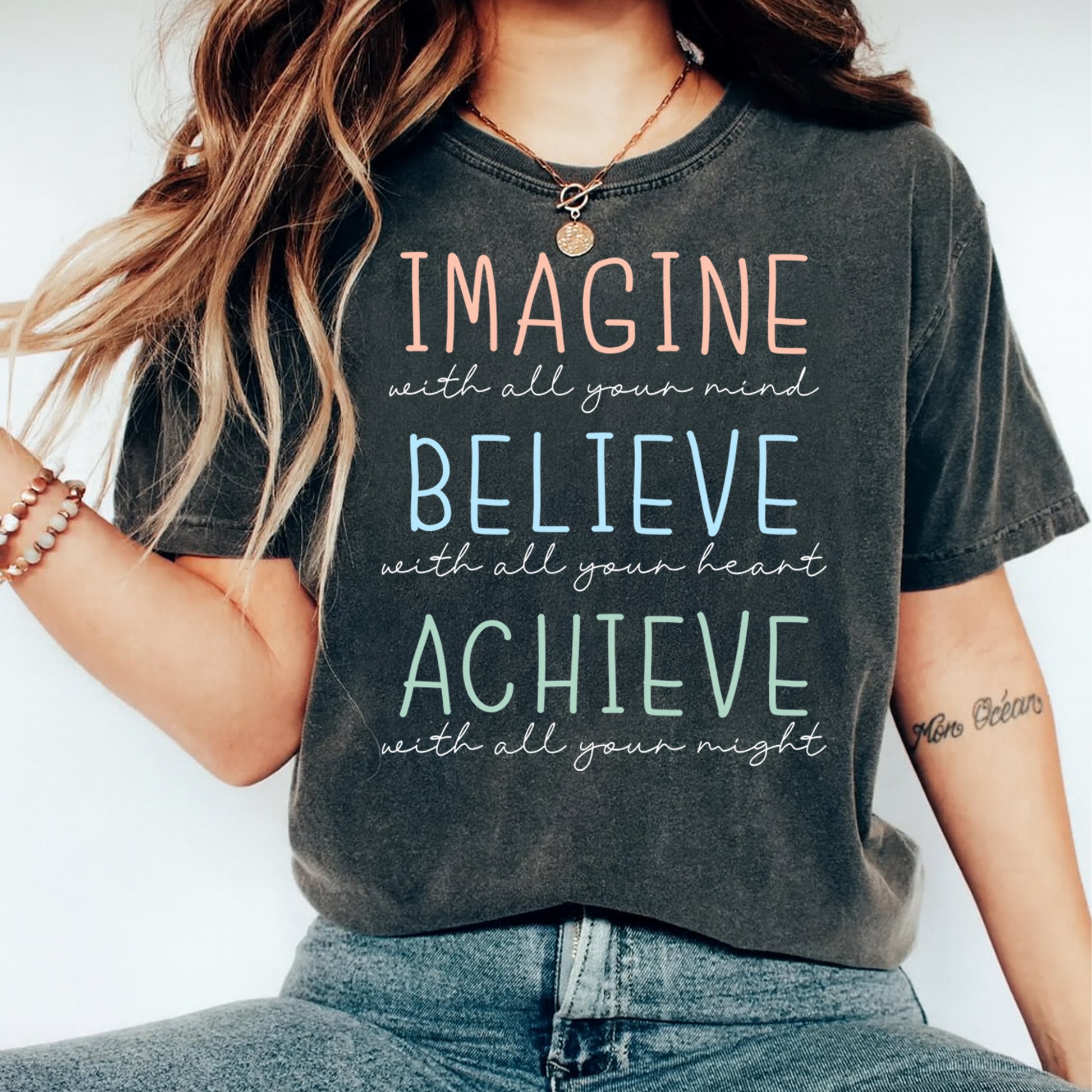 Black shirt mockup featuring a motivational ready to press dtf transfer with the phrase Imagine Believe Achieve in soft pastel lettering.