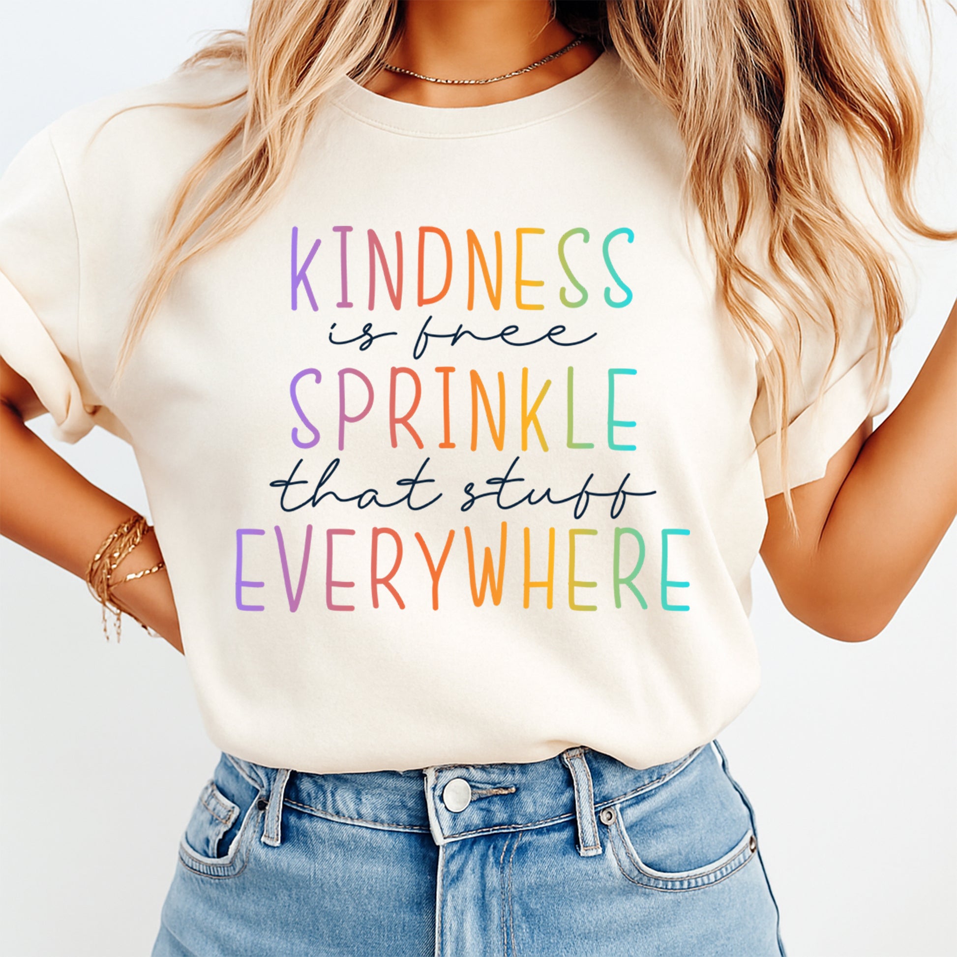 Cream shirt mockup featuring a colorful kindness ready to press dtf transfer with the phrase Kindness is free Sprinkle that stuff Everywhere.