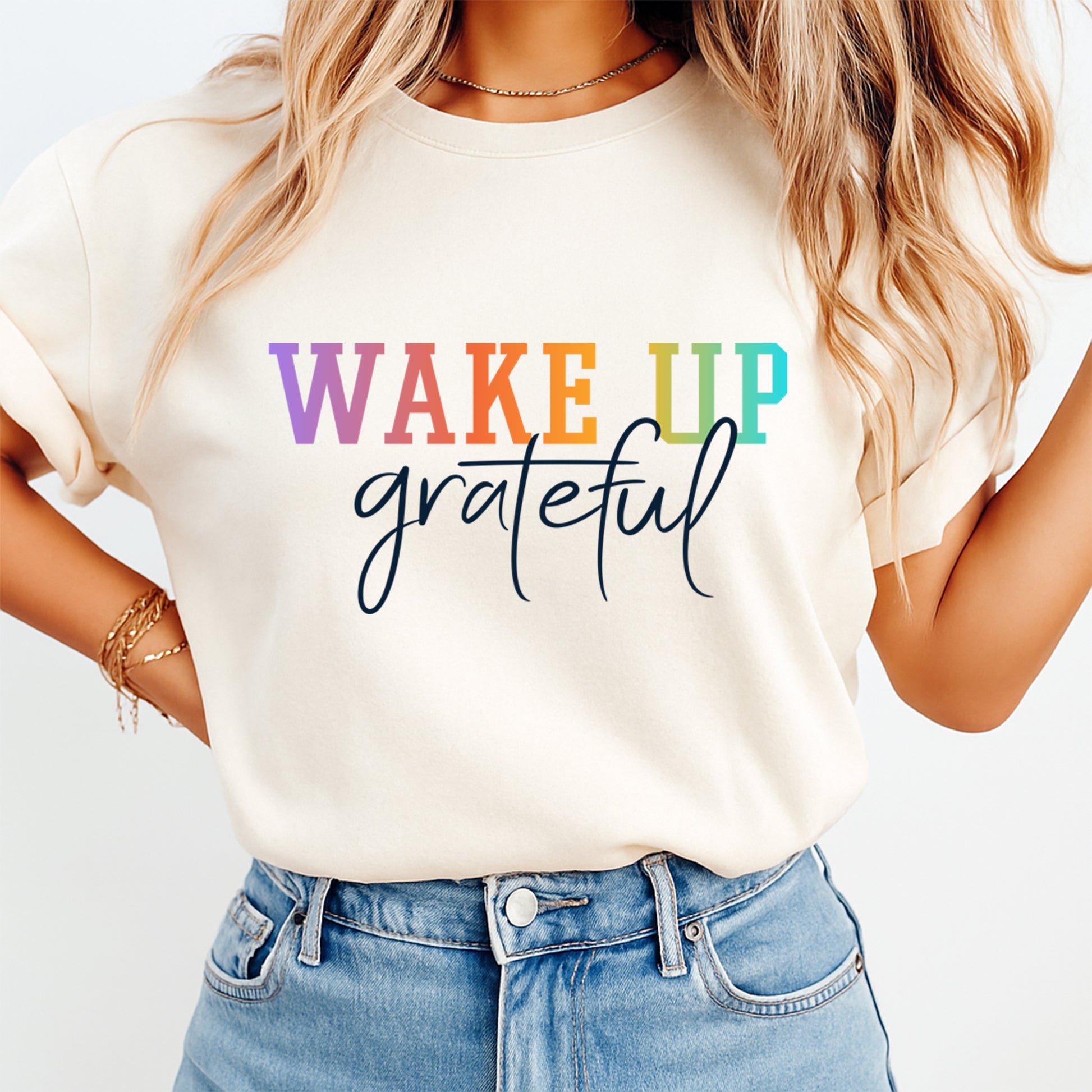 Lifestyle mockup of a cream shirt with an inspirational ready to press dtf graphic that says Wake Up Grateful.