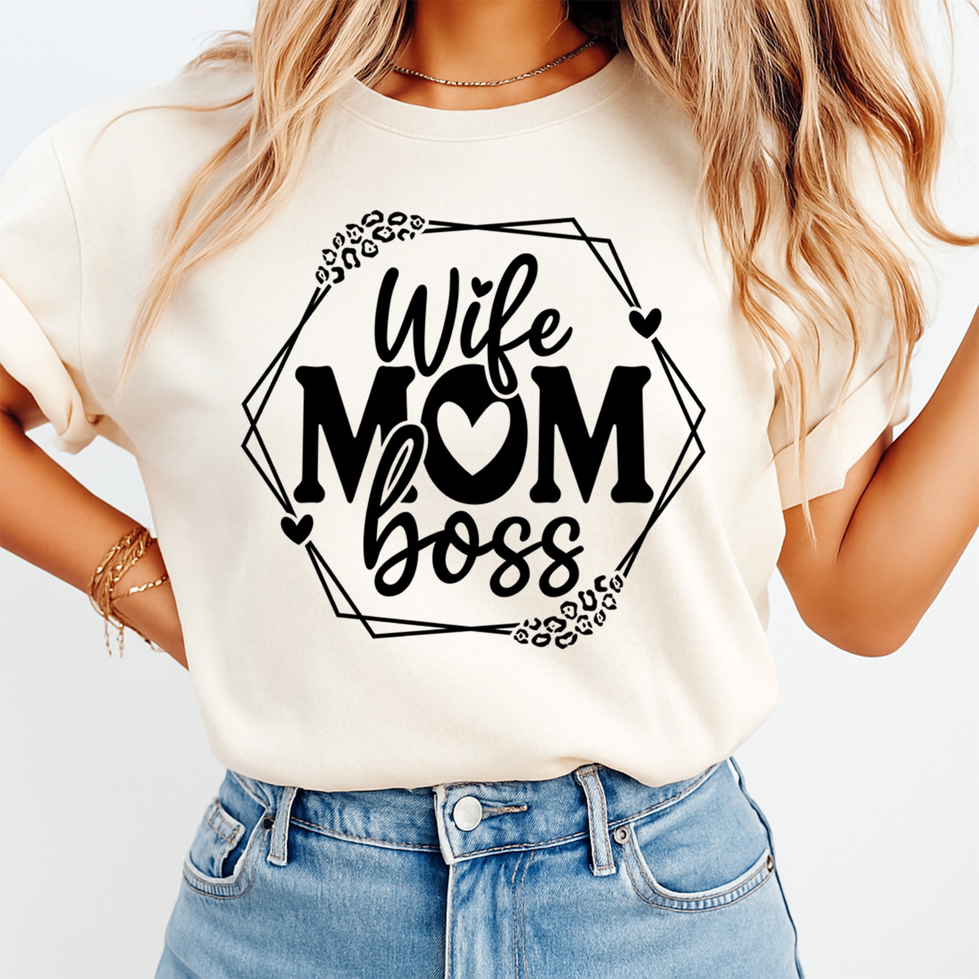 Lifestyle mockup of a cream shirt featuring a black Wife Mom Boss ready to press dtf graphic with hearts, leopard accents, and geometric frame.