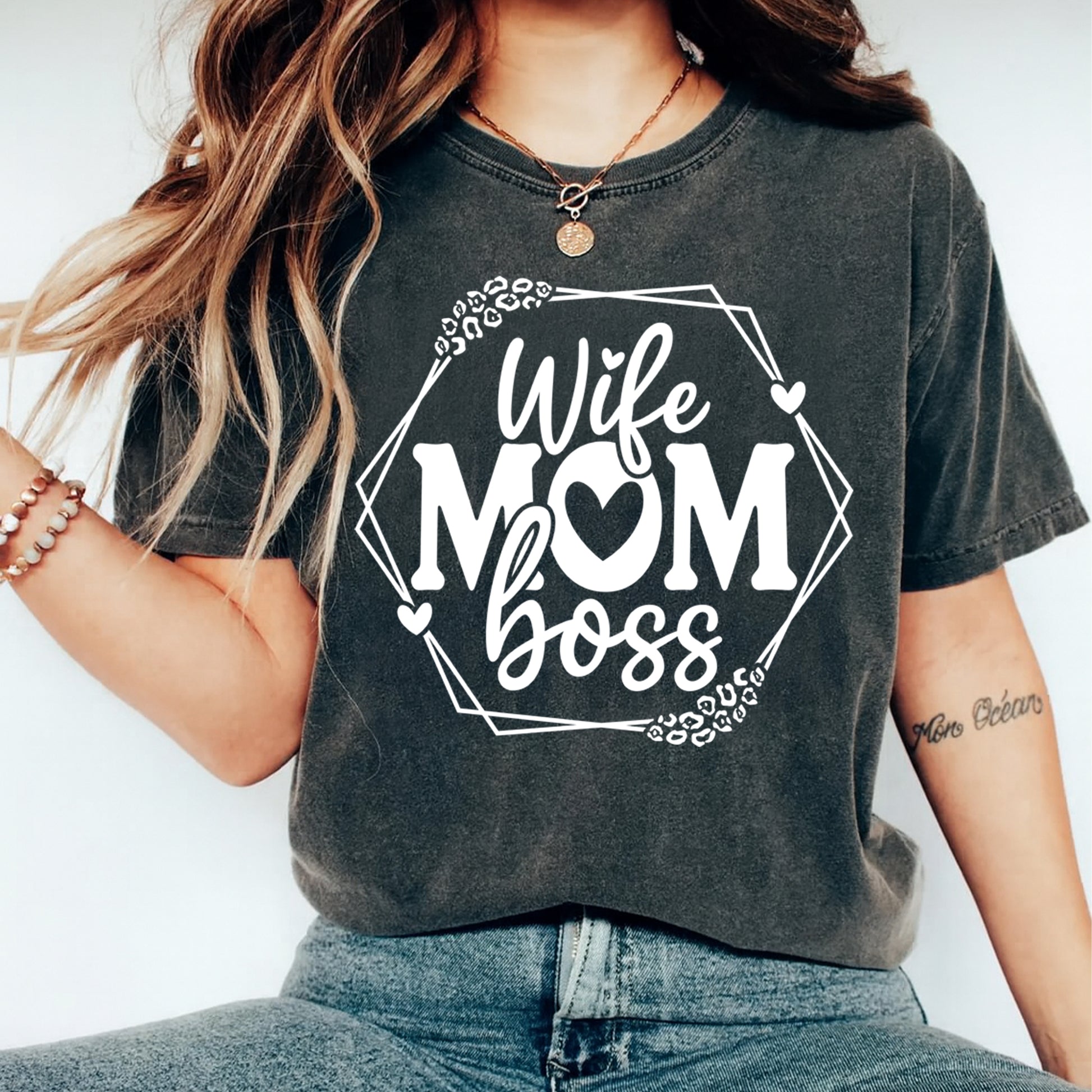 Lifestyle mockup of a dark gray shirt featuring a white Wife Mom Boss ready to press dtf graphic with hearts, leopard accents, and geometric frame.