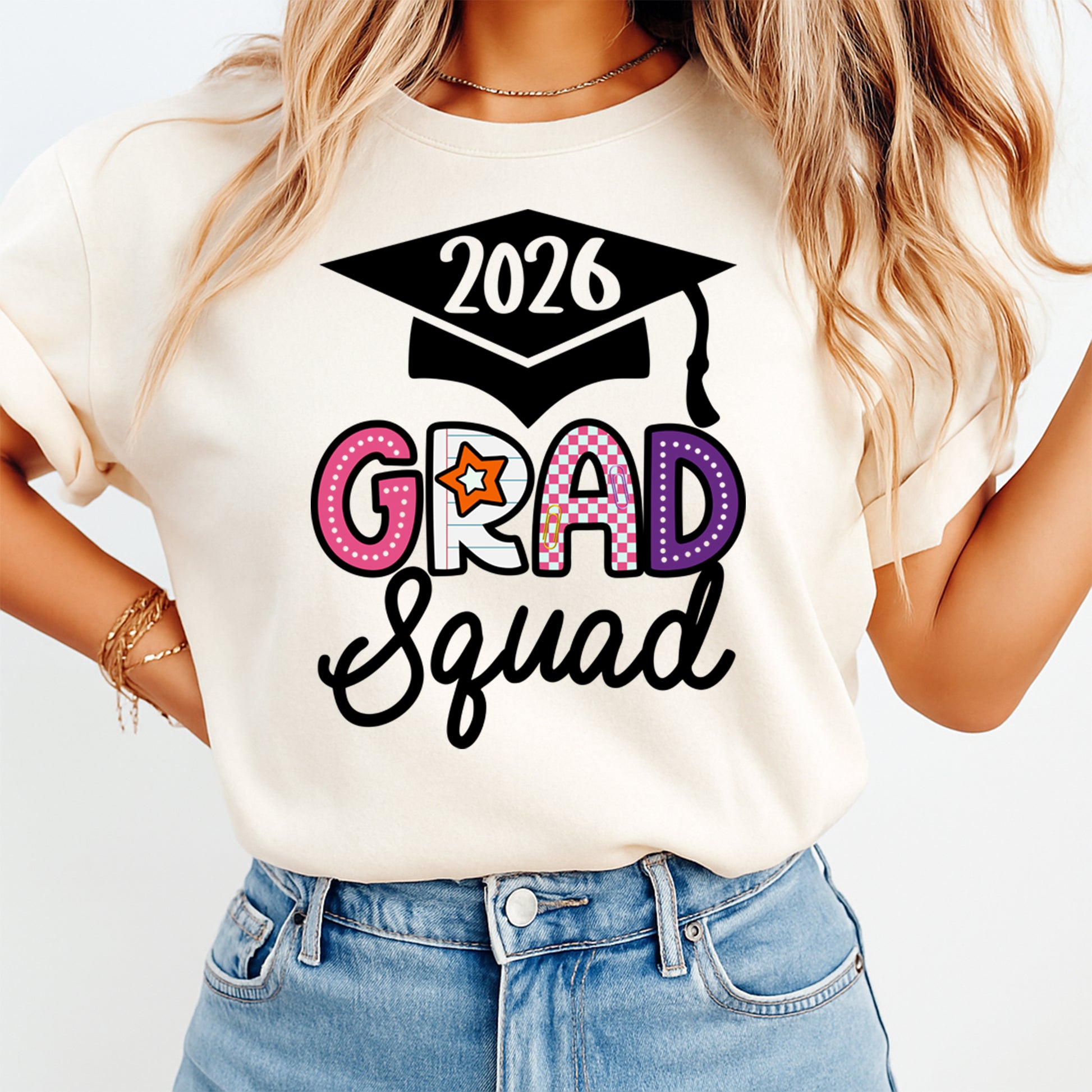 Cream shirt mockup featuring a Grad Squad ready to press dtf transfer with colorful varsity letters, star accents, and black script text.