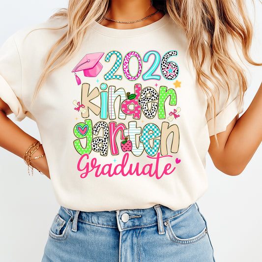 Mockup of kindergarten graduation ready to press dtf transfer on a cream shirt featuring colorful 2026 kindergarten graduate artwork for DIY graduation shirts.