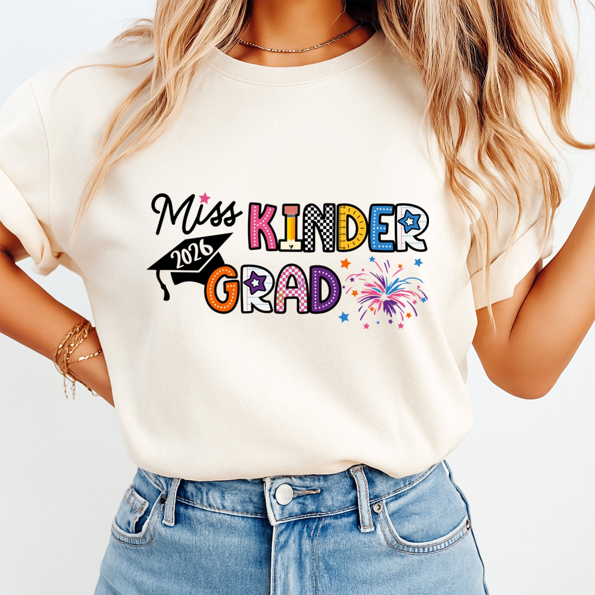Kindergarten graduation shirt mockup featuring “Miss Kinder Grad 2026” text, colorful letters, graduation cap, stars, and fireworks ready to press dtf artwork.