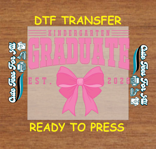Ready to press dtf kindergarten graduation iron on heat transfer with pink graduate lettering, “EST. 2026” text, and large bow graphic.