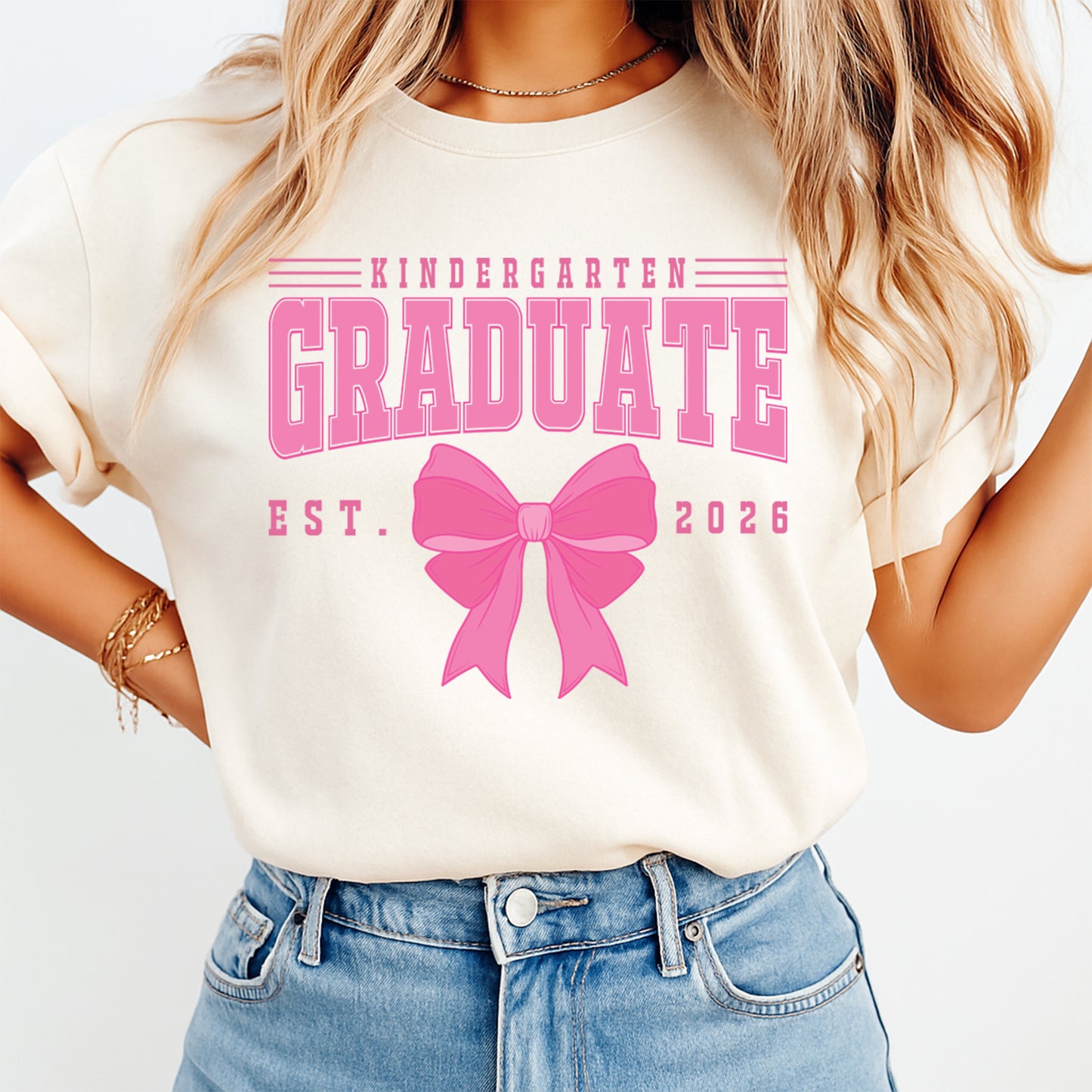 Kindergarten graduation shirt mockup featuring pink varsity graduate text, large bow graphic, and ready to press dtf transfer artwork for DIY graduation shirts.