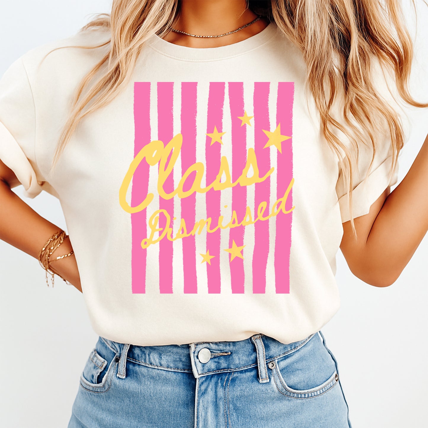 Person wearing a white t-shirt with pink and yellow 'Class Dismissed' design.