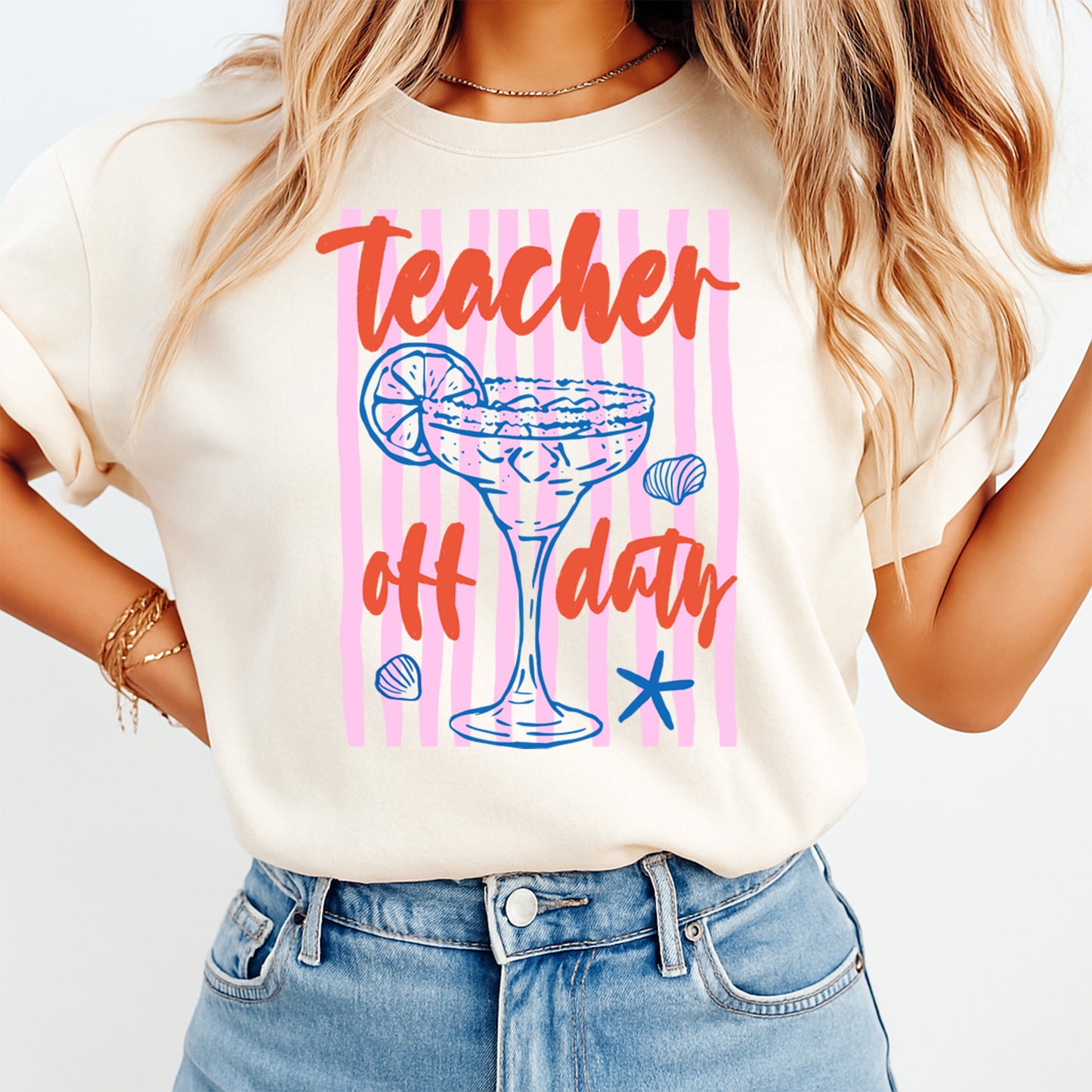 Person wearing a t-shirt with 'Teacher off duty' design on a plain background