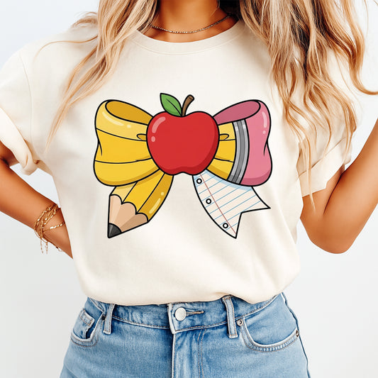 Teacher bow DTF transfer pressed on cream shirt with apple, pencil, eraser, and notebook paper school design