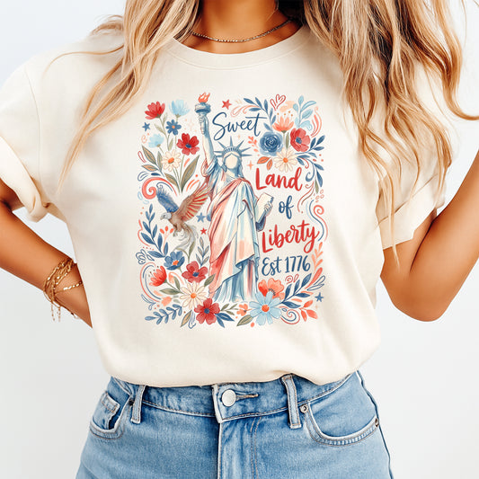 Person wearing a t-shirt with a colorful graphic design featuring the Statue of Liberty and floral elements.