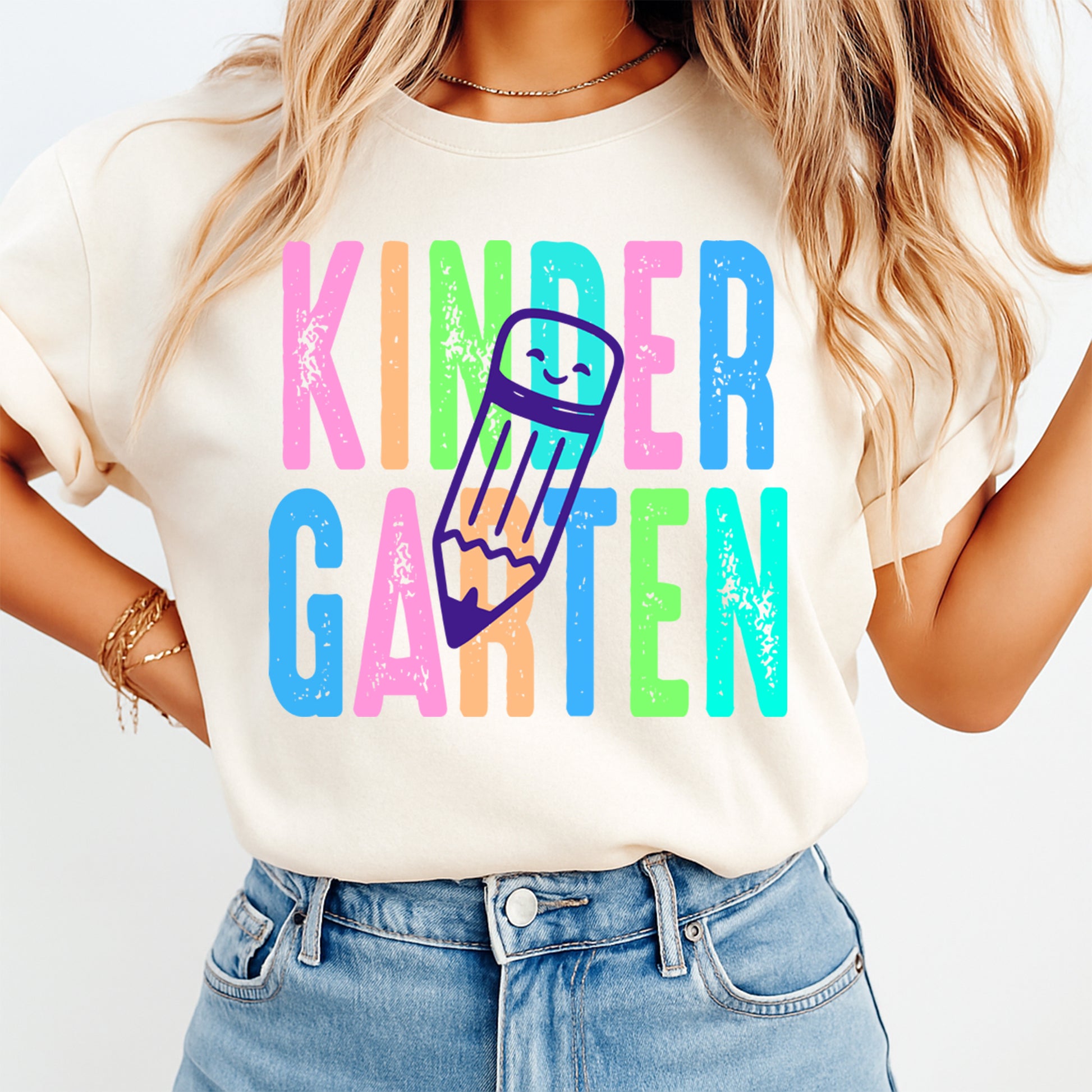 Person wearing a white t-shirt with 'KINDER GARTEN' in colorful letters and a pencil graphic.