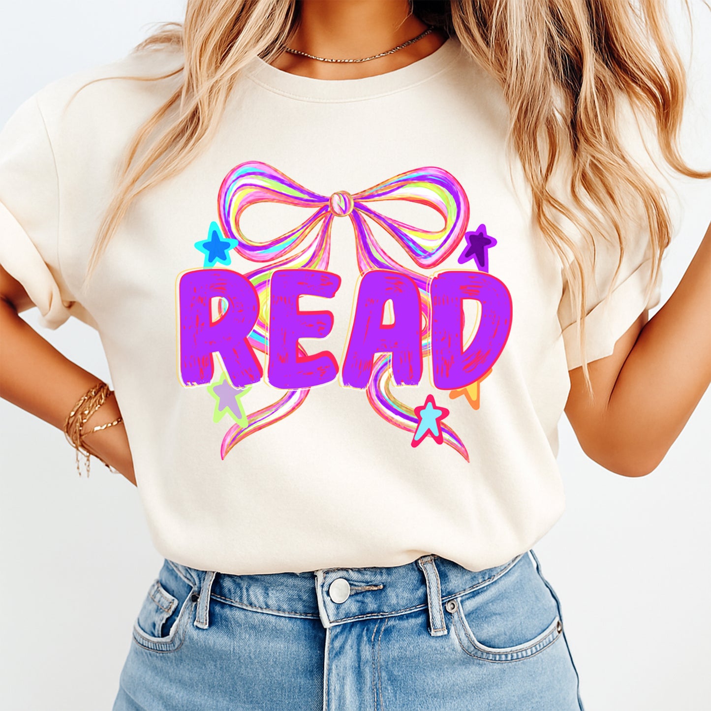 Person wearing a white t-shirt with a colorful 'READ' design and blue jeans.