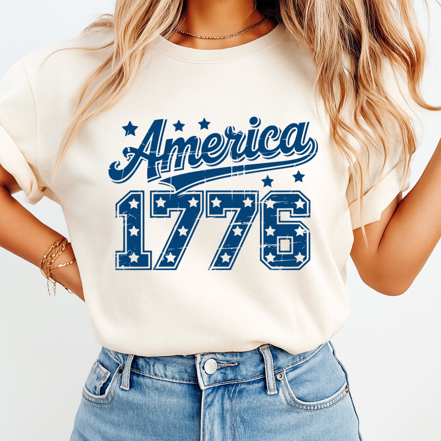 Person wearing a white t-shirt with 'America 1776' design on a plain background
