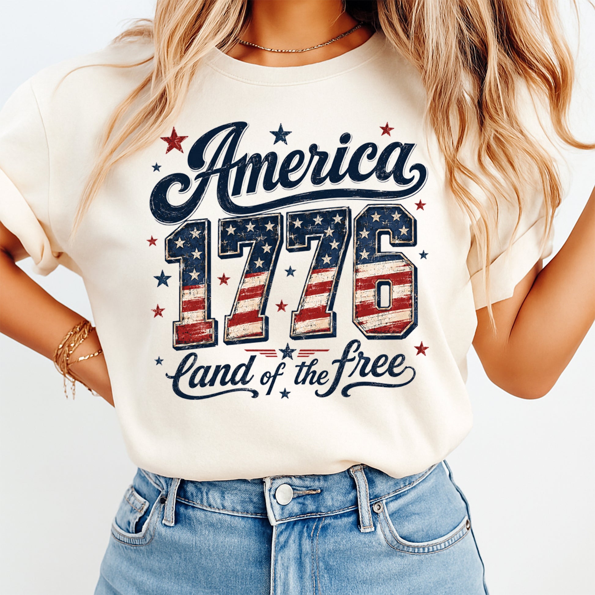 Person wearing a t-shirt with 'America 1776 Land of the Free' design on a plain background