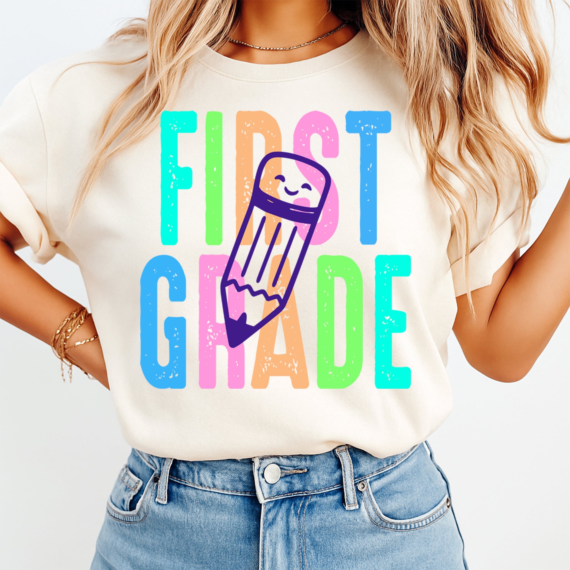 First grade teacher shirt mockup with colorful pencil school DTF transfer on cream T-shirt