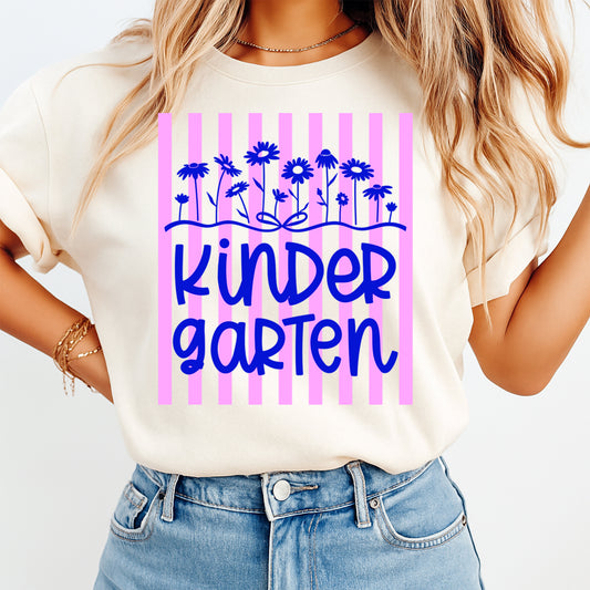 Person wearing a white t-shirt with 'KinderGarten' design on a plain background