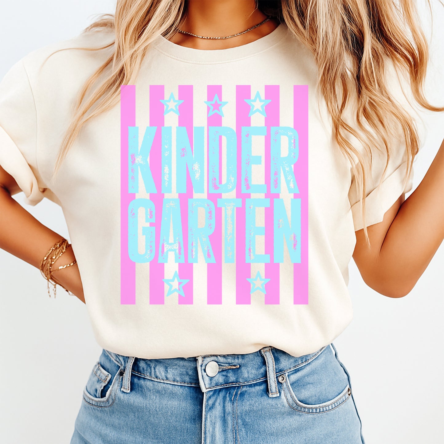 Person wearing a white t-shirt with 'KINDER GARTEN' text and pink stripes.
