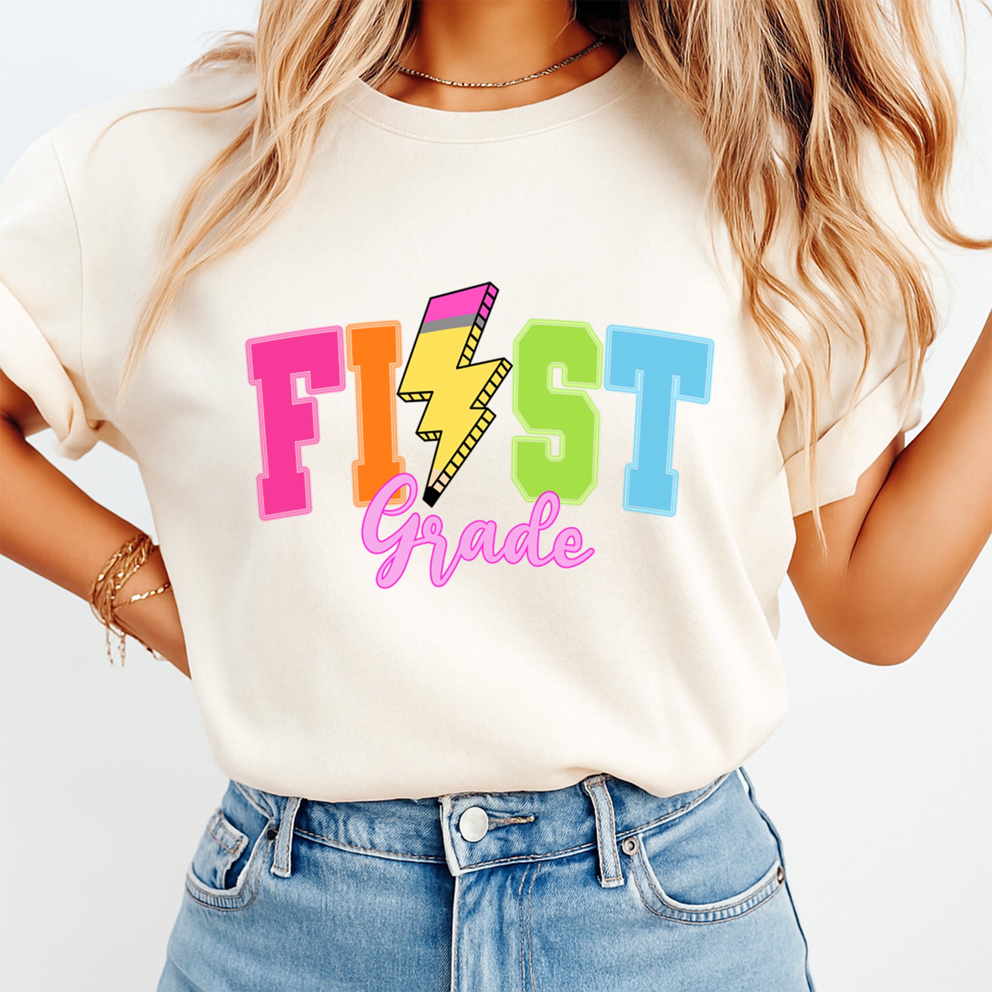 Person wearing a white t-shirt with colorful 'FIRST Grade' text design.