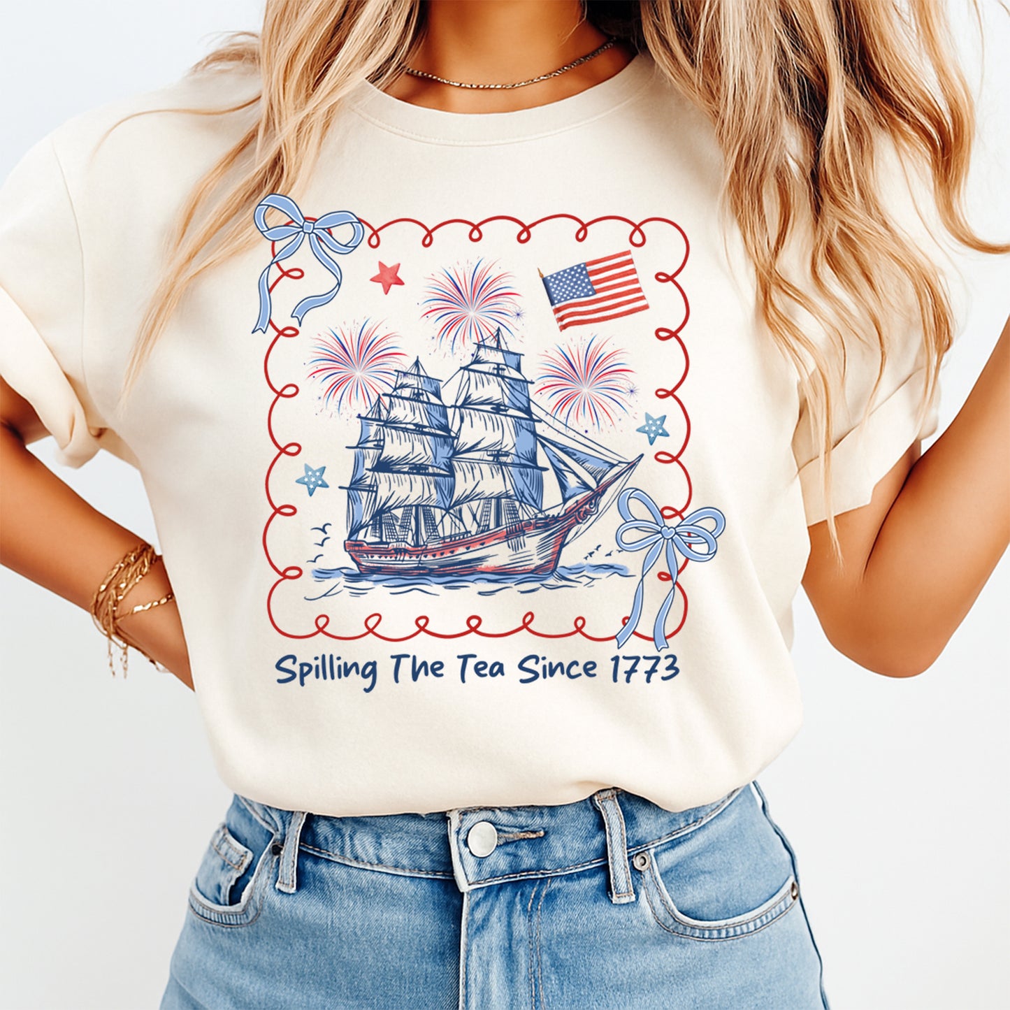 Person wearing a t-shirt with a ship and American flag design, text 'Spilling The Tea Since 1773', on a plain background.