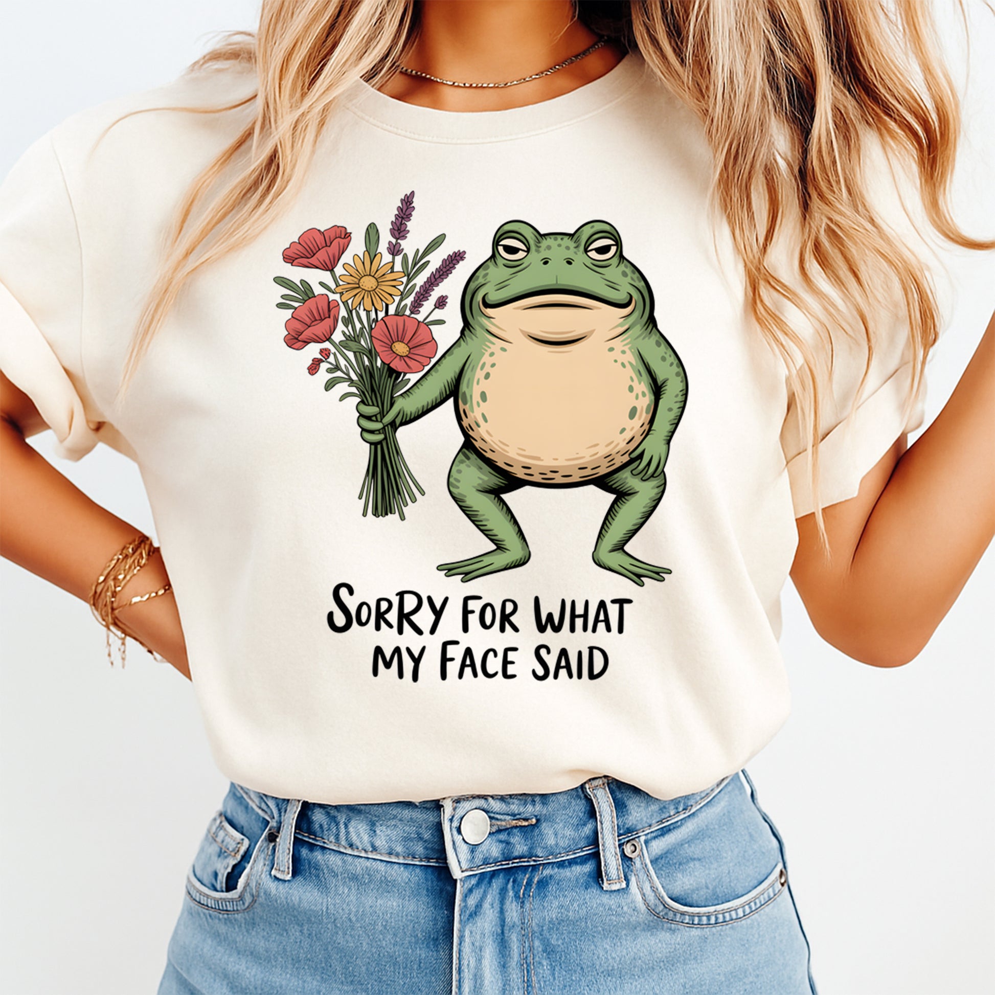 Person wearing a white t-shirt with a frog holding flowers and text, on a plain background