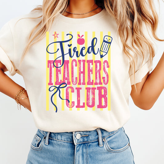 Person wearing a t-shirt with 'Tired Teachers Club' text and graphics.