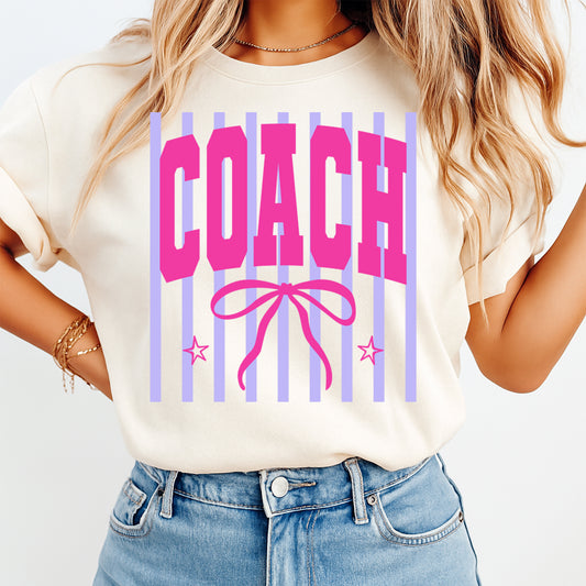 Person wearing a white t-shirt with 'COACH' design on a plain background