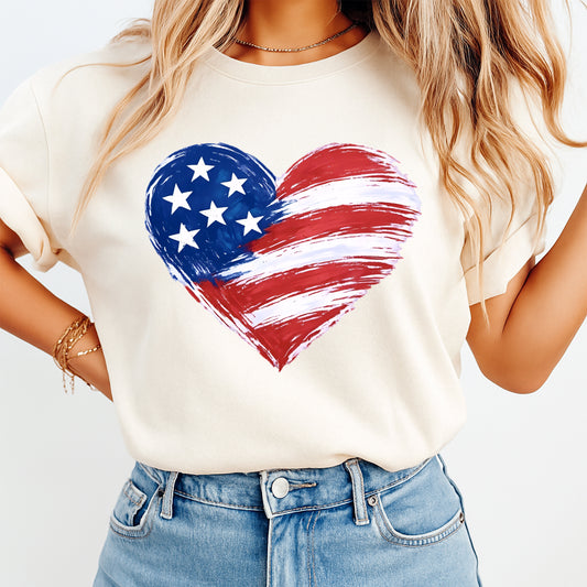Person wearing a white t-shirt with an American flag heart design on a plain background