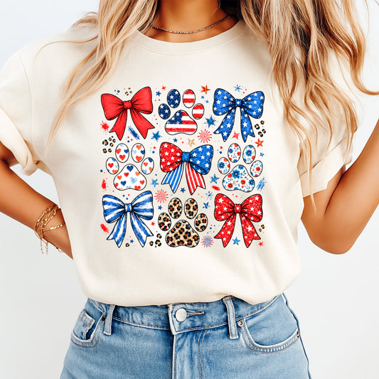 Person wearing a white t-shirt with red, blue, and white designs including bows and paw prints.
