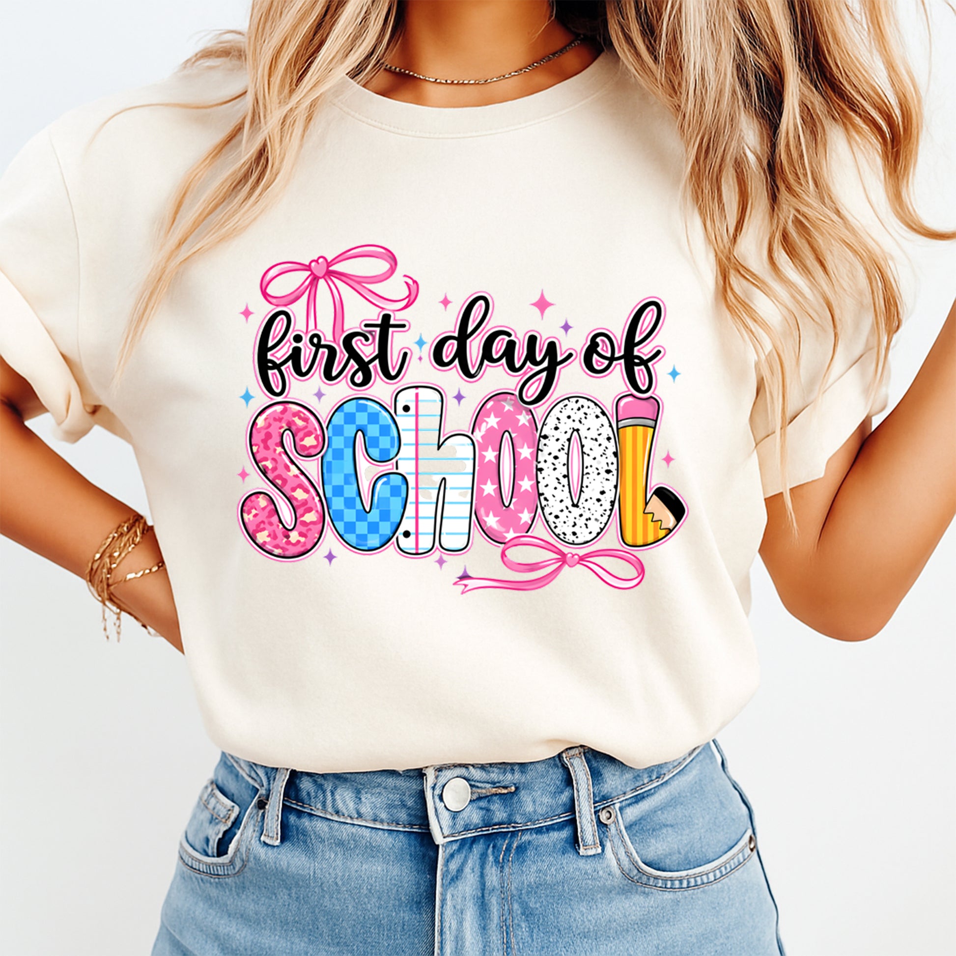 Person wearing a white t-shirt with 'first day of school' text and graphics.