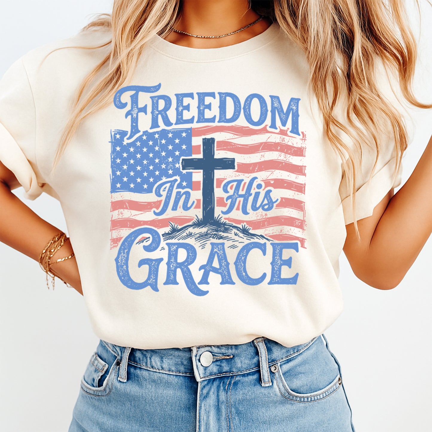 Woman wearing cream shirt with Fourth of July Freedom In His Grace DTF transfer featuring cross and American flag
