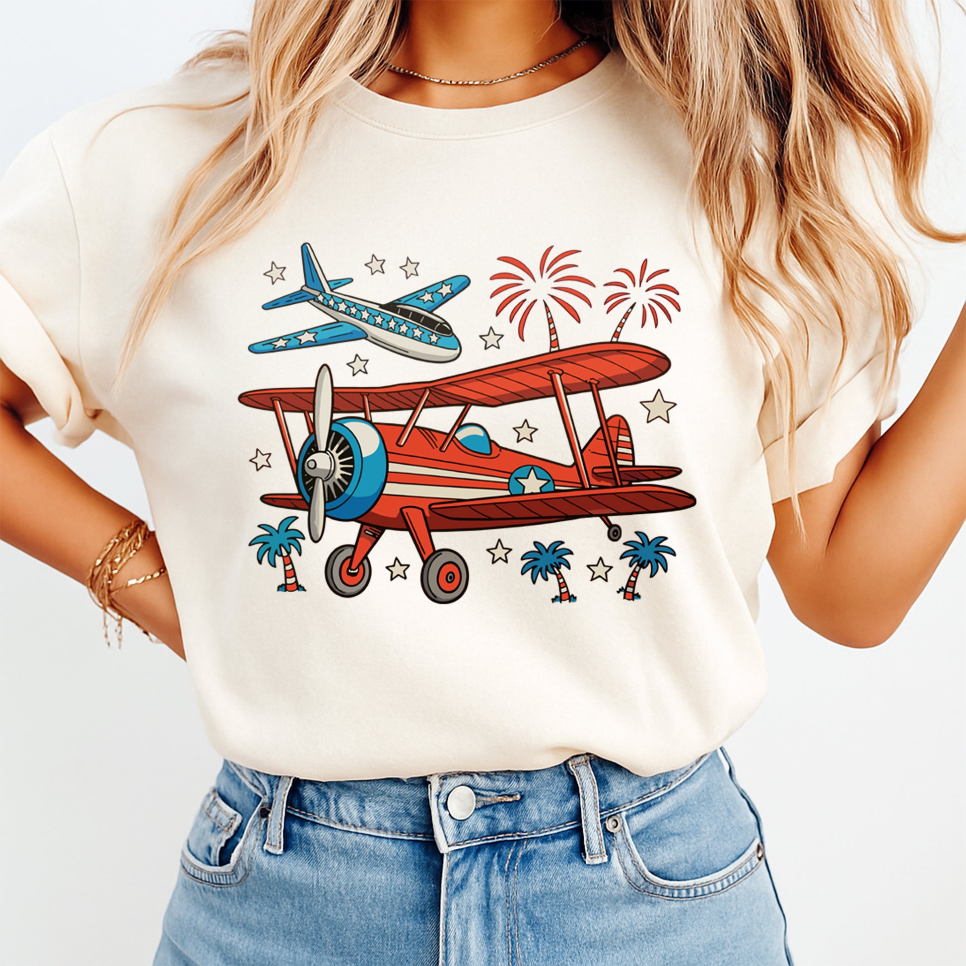 Woman wearing cream shirt with Fourth of July patriotic airplane DTF transfer featuring red biplane, blue jet, fireworks, and stars