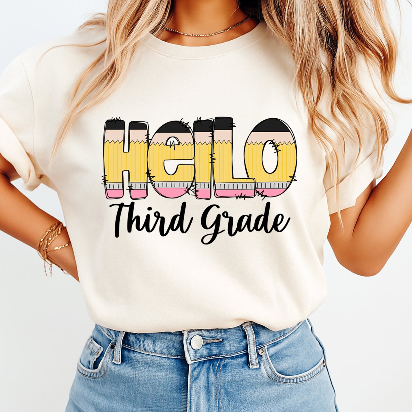 Person wearing a white t-shirt with 'Hello Third Grade' text design.