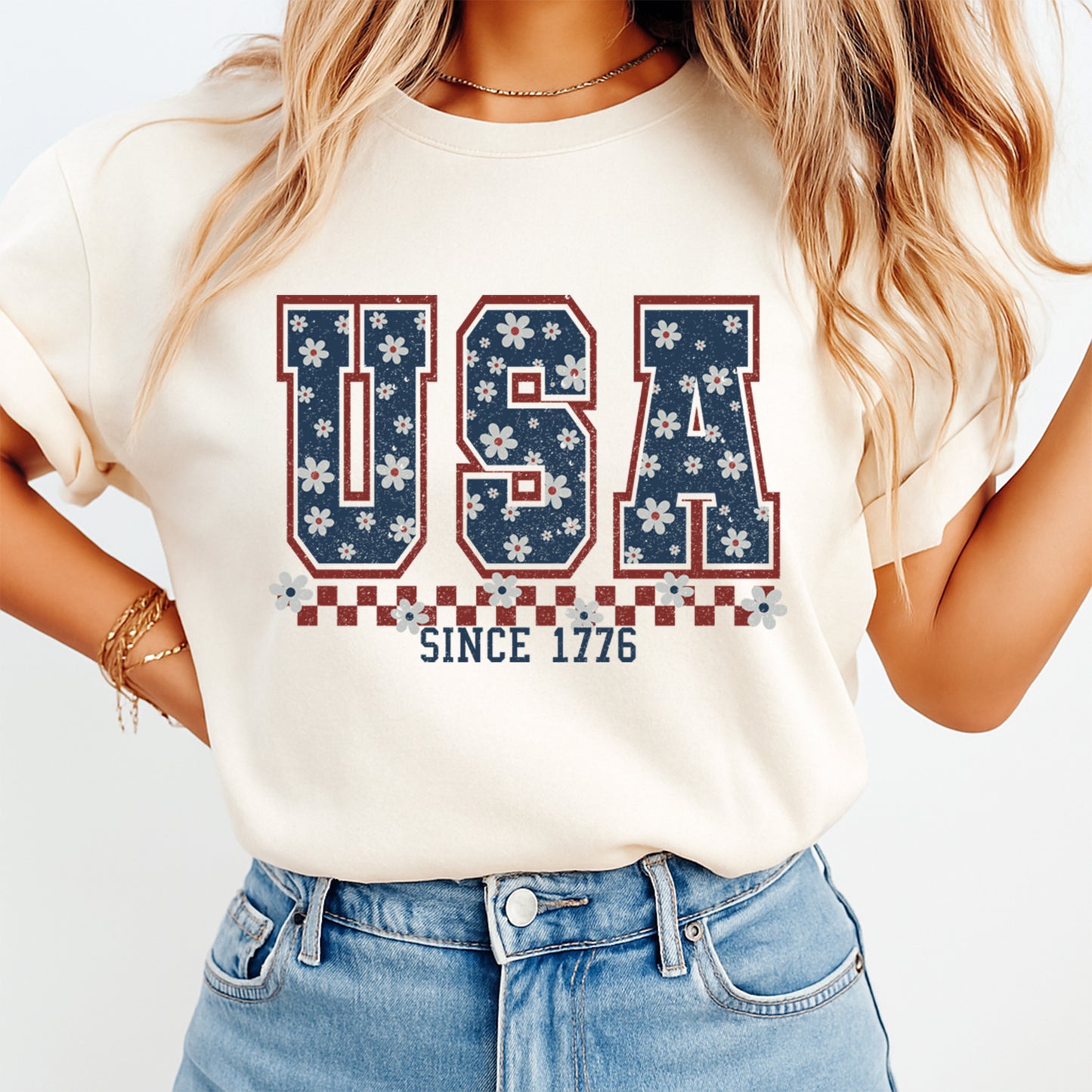 Woman wearing cream shirt with Fourth of July USA Since 1776 DTF transfer featuring floral varsity letters