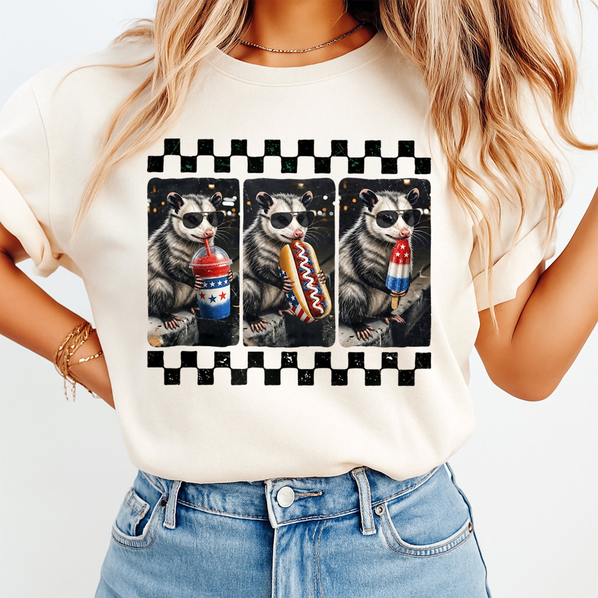 Woman wearing cream shirt with Fourth of July patriotic possum DTF transfer featuring sunglasses, hot dog, drink, and popsicle