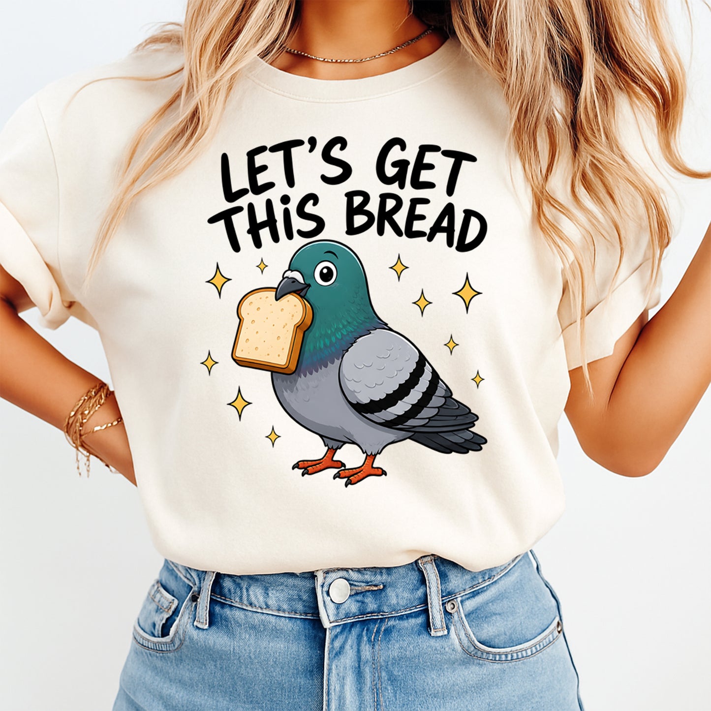 Person wearing a t-shirt with a pigeon holding bread and text 'LET'S GET THIS BREAD' on a plain background
