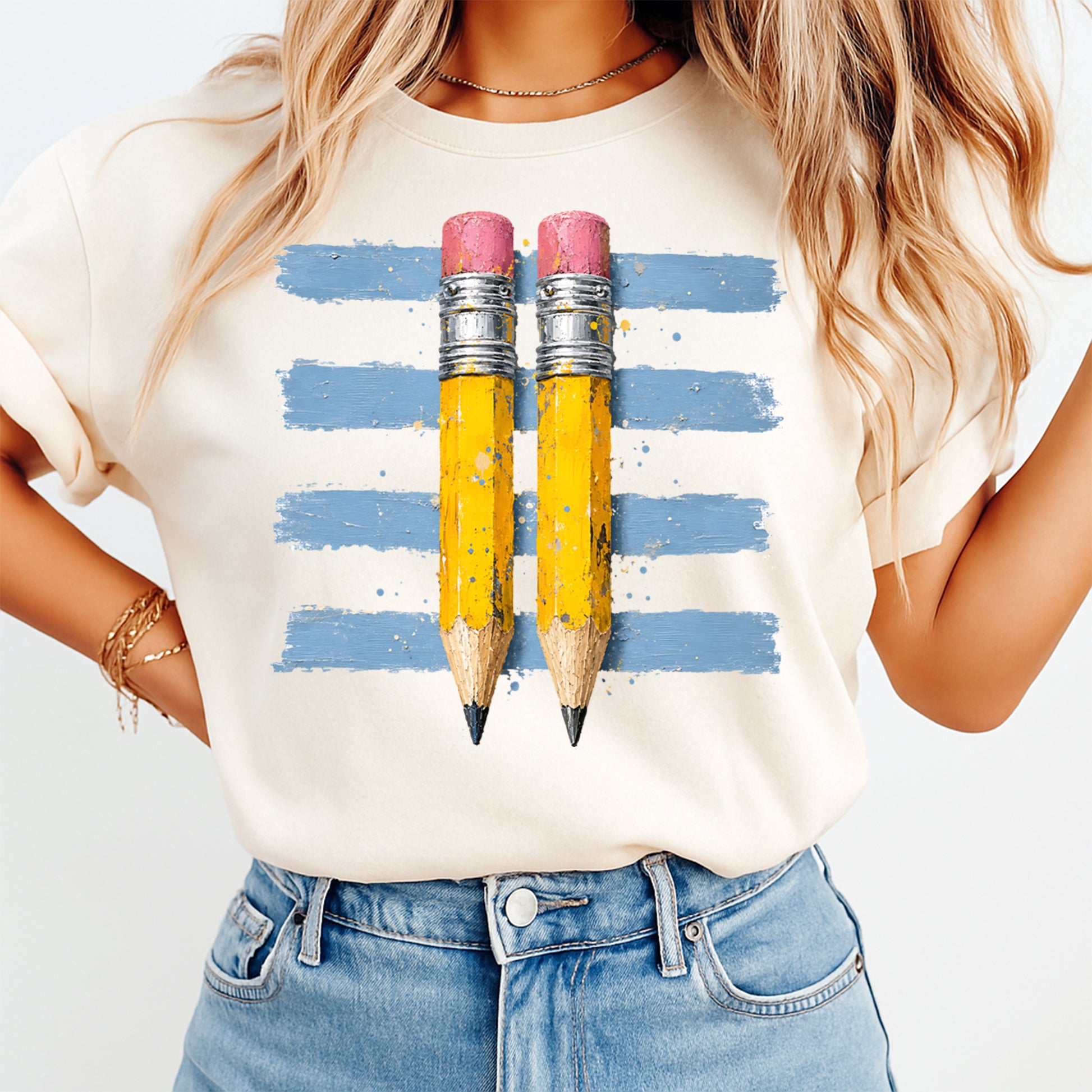 Person wearing a t-shirt with a graphic of two pencils on a striped background