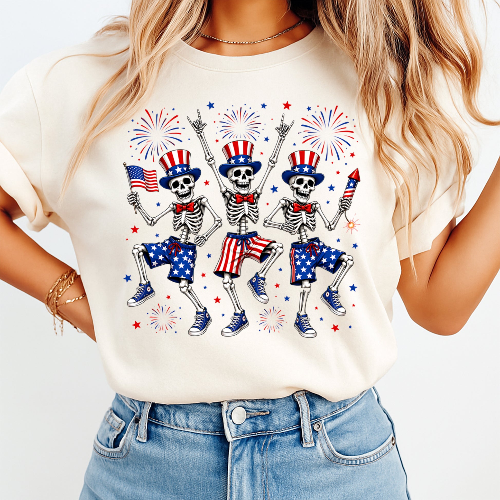 Person wearing a white t-shirt with skeleton graphics holding American flags and fireworks.