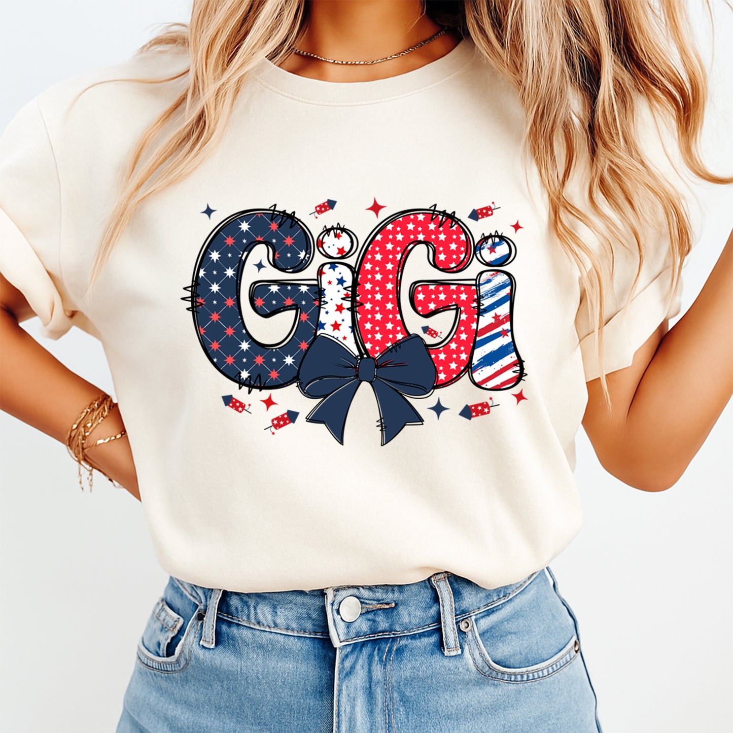 Person wearing a white t-shirt with 'GIGI' design, featuring stars and a bow, on a plain background.