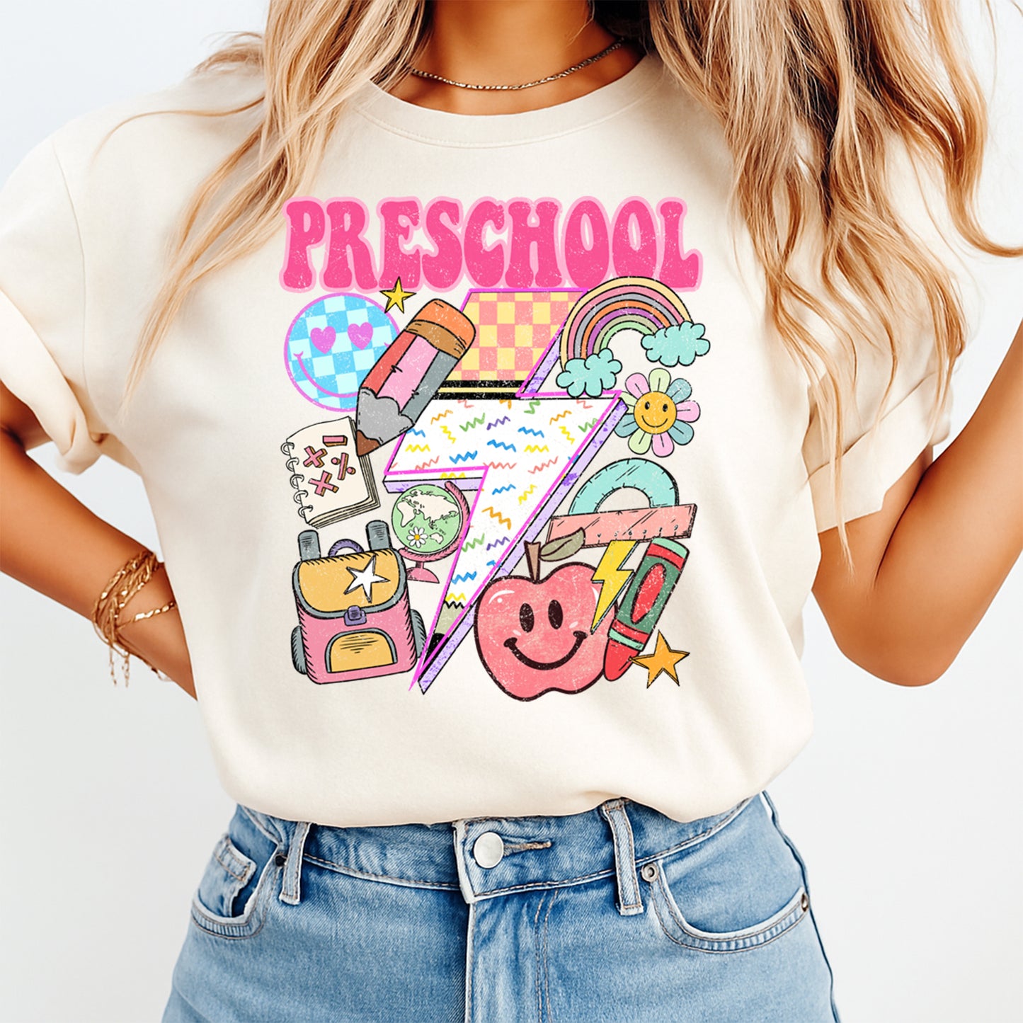 Person wearing a t-shirt with colorful preschool graphics and text.