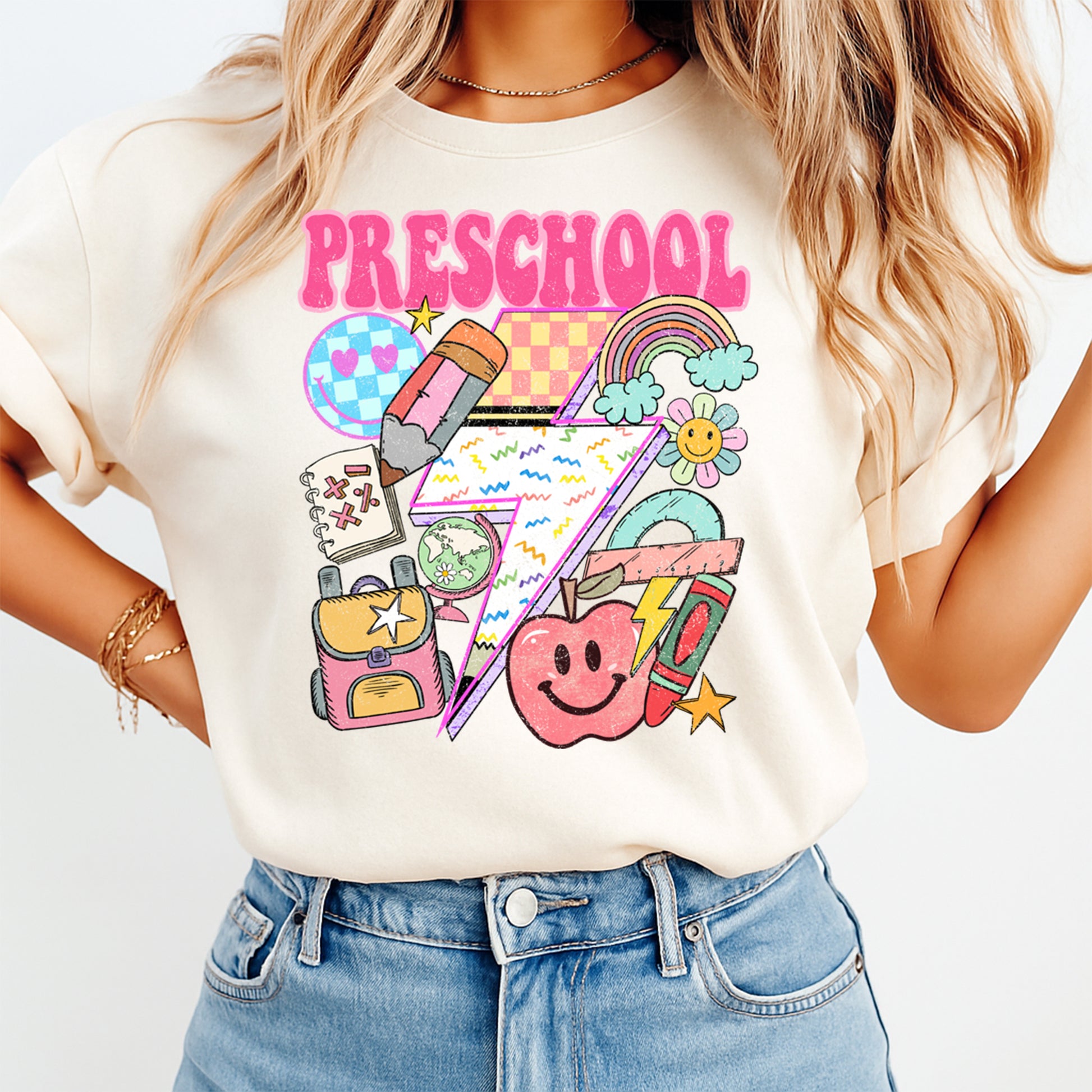 Person wearing a t-shirt with colorful preschool graphics and text.