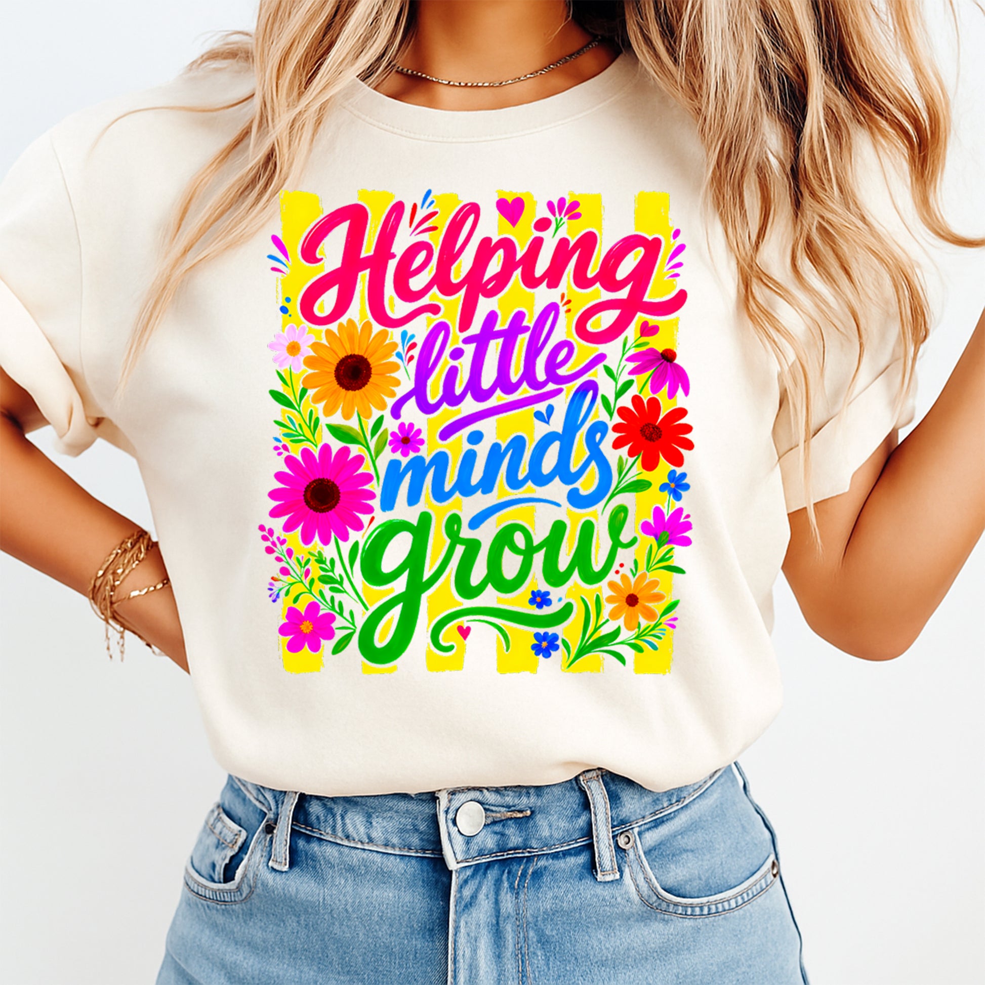 Person wearing a white t-shirt with colorful text and floral designs on a plain background