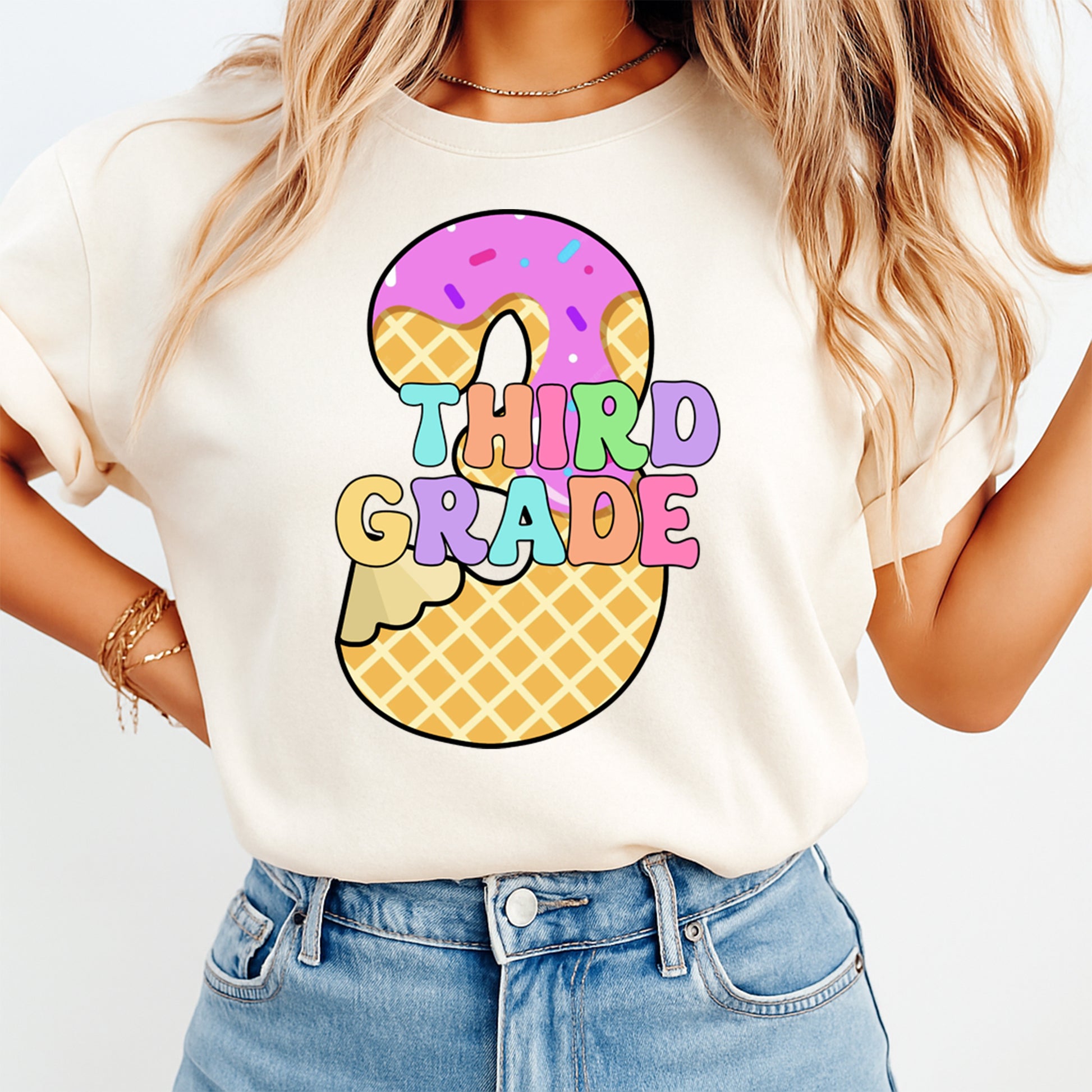 Person wearing a white t-shirt with 'Third Grade' and donut design on a plain background