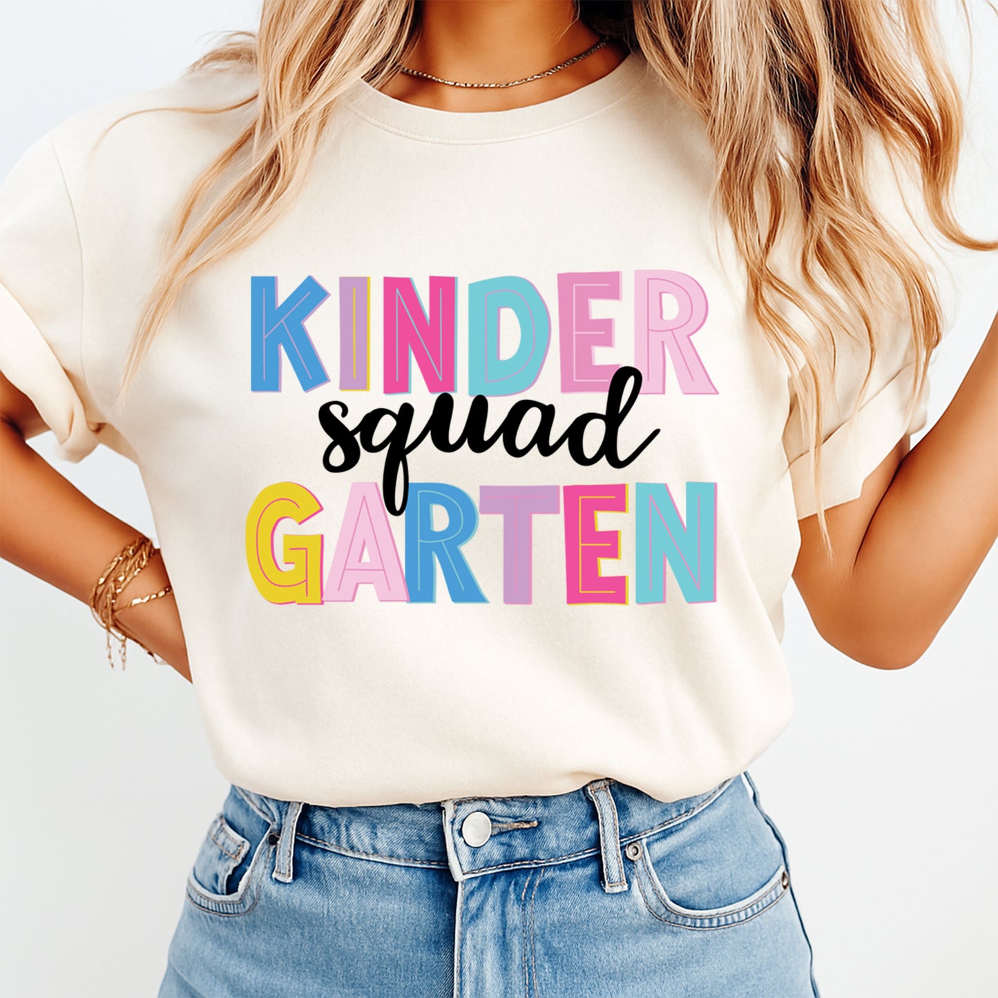 Person wearing a white t-shirt with 'KINDERGARTEN SQUAD' text in colorful letters on a plain background