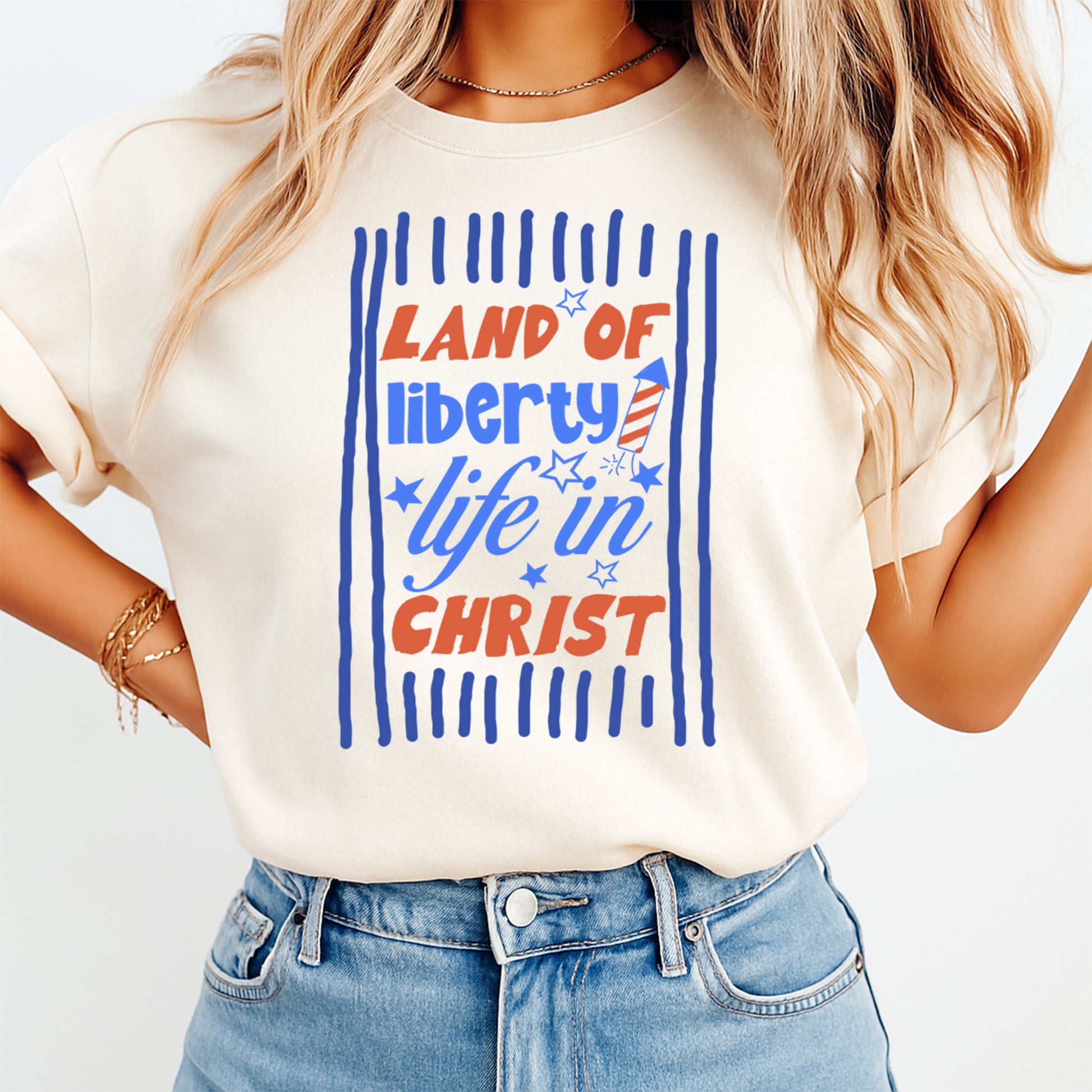 Person wearing a t-shirt with 'Land of Liberty, Life in Christ' text design.