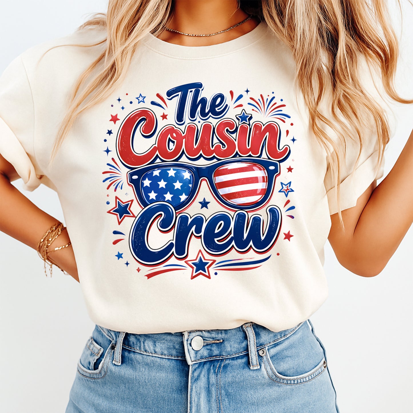 Person wearing a white t-shirt with 'The Cousin Crew' design featuring American flags and sunglasses.