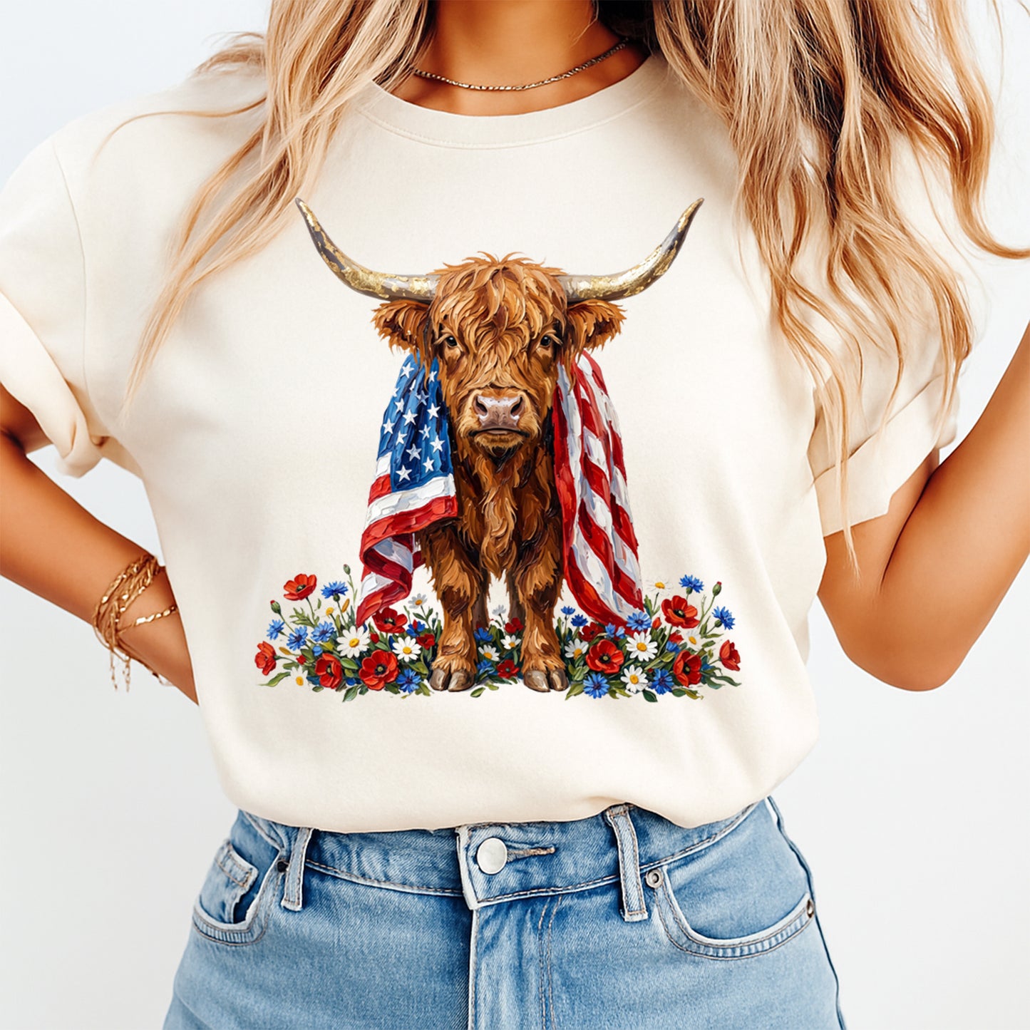 Fourth of July highland cow DTF transfer mockup on cream shirt with American flag draped over cow, red white blue flowers, and western patriotic design.