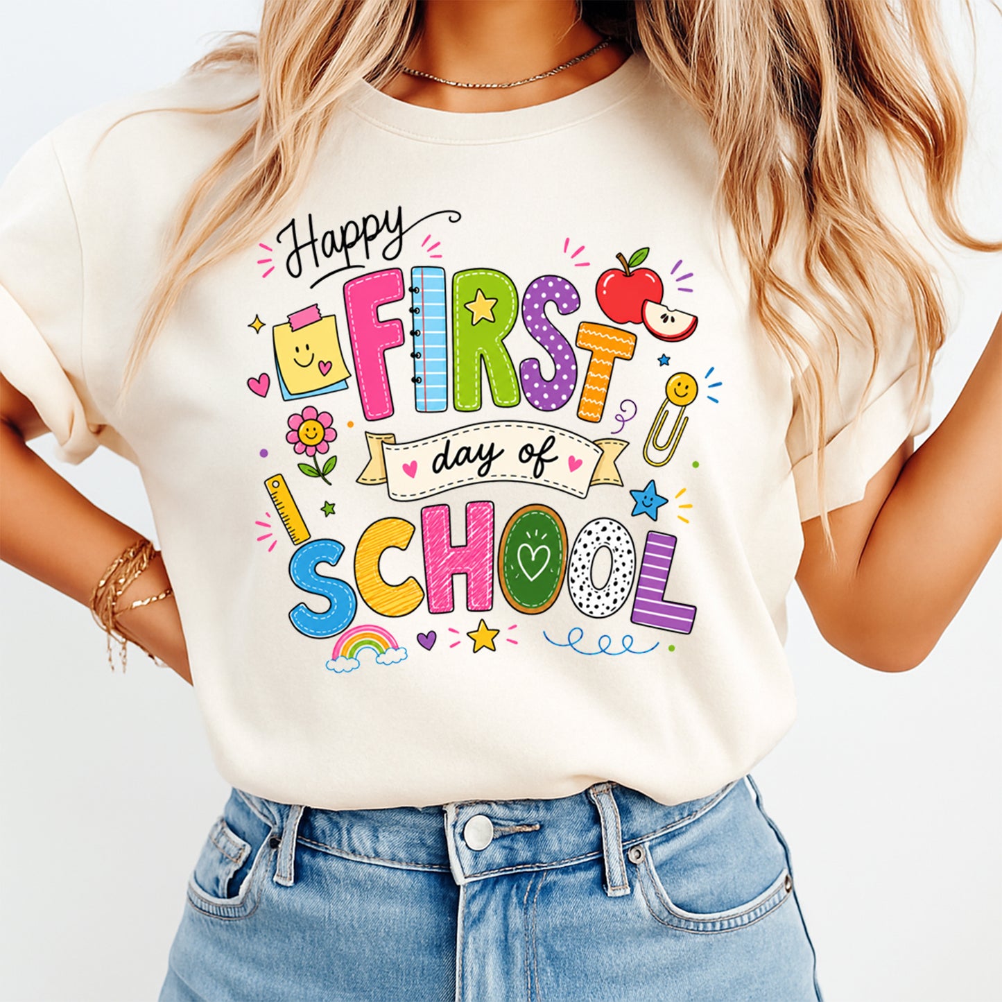 Person wearing a white t-shirt with 'Happy First Day of School' text and graphics.