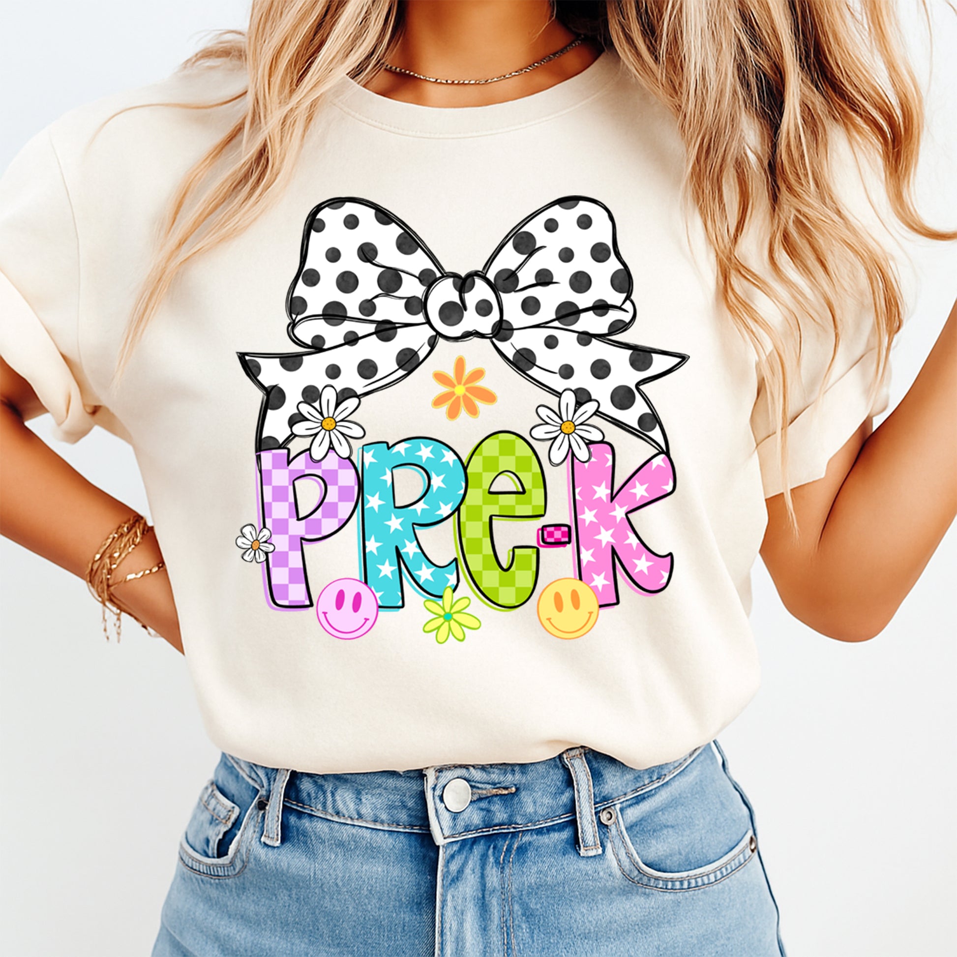 Person wearing a white t-shirt with a colorful 'PRE-K' design and polka dot bow.
