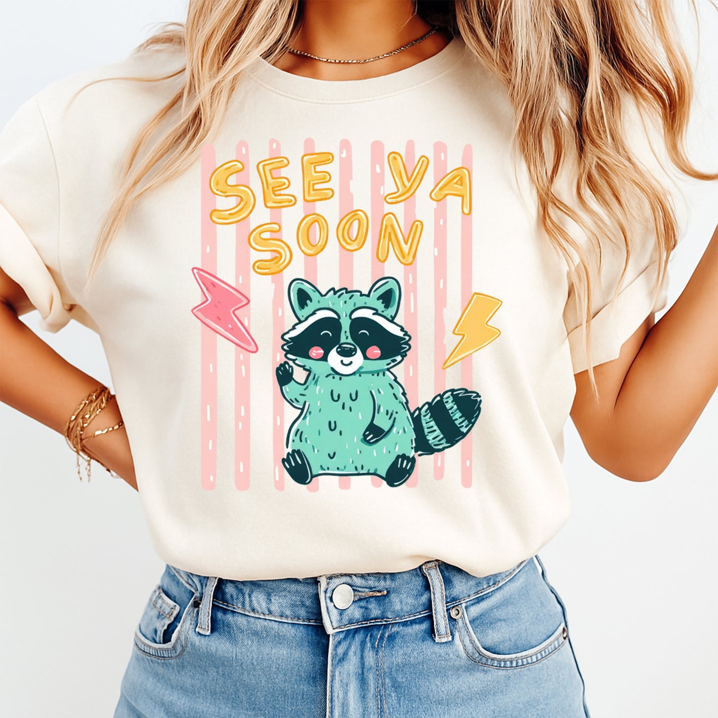 Person wearing a t-shirt with a raccoon graphic and 'See Ya Soon' text on a plain background