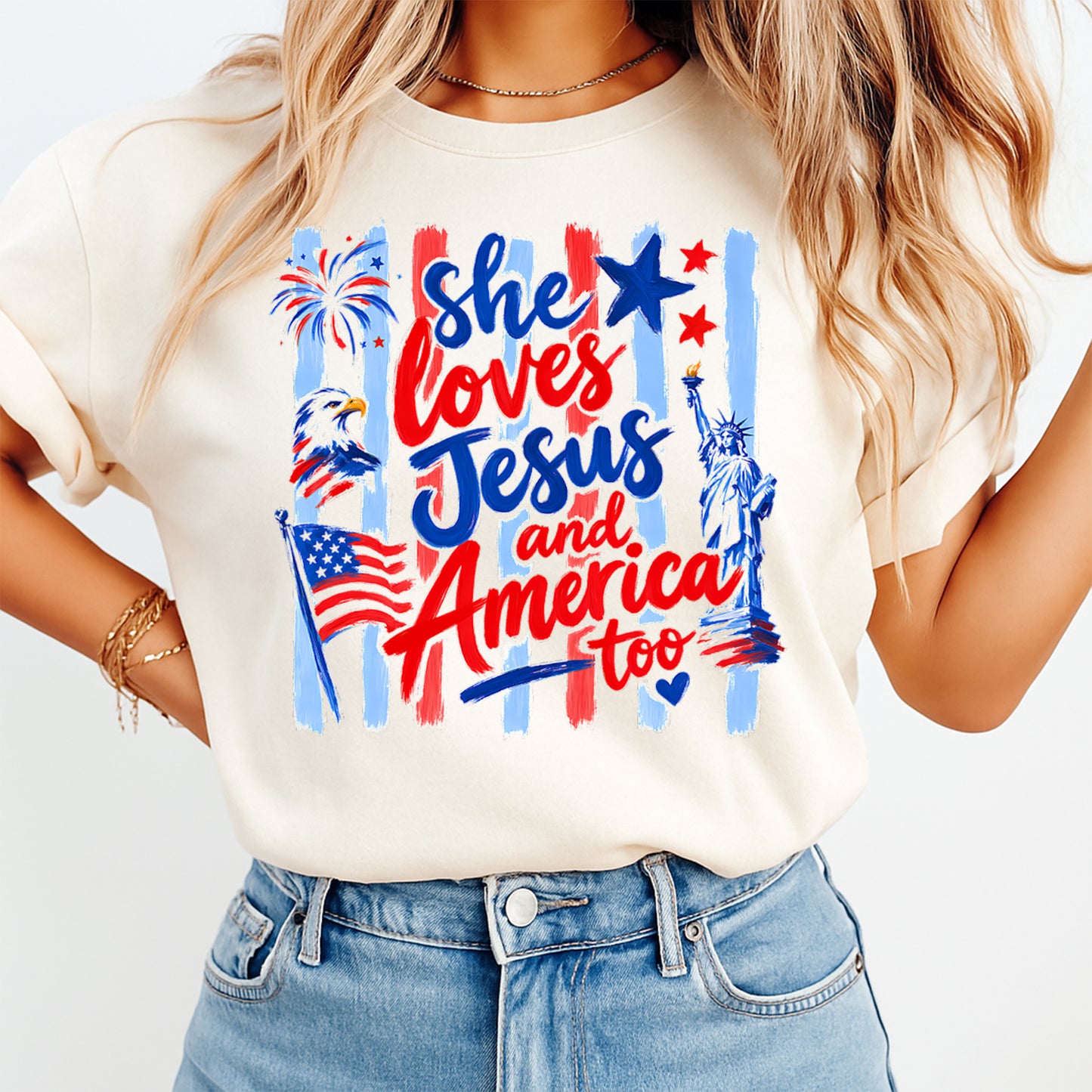 Fourth of July She Loves Jesus And America DTF transfer mockup on cream shirt with patriotic red white blue lettering, eagle, flag, Statue of Liberty, and fireworks.